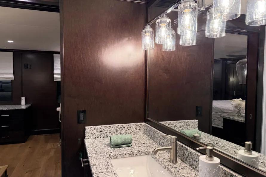 Luxurious bathroom interior of 2019 Sumerset Houseboat with granite countertop and elegant lighting.