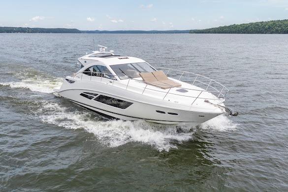2016 Sea Ray Sundancer 510 cruising on a serene lake under a clear sky.