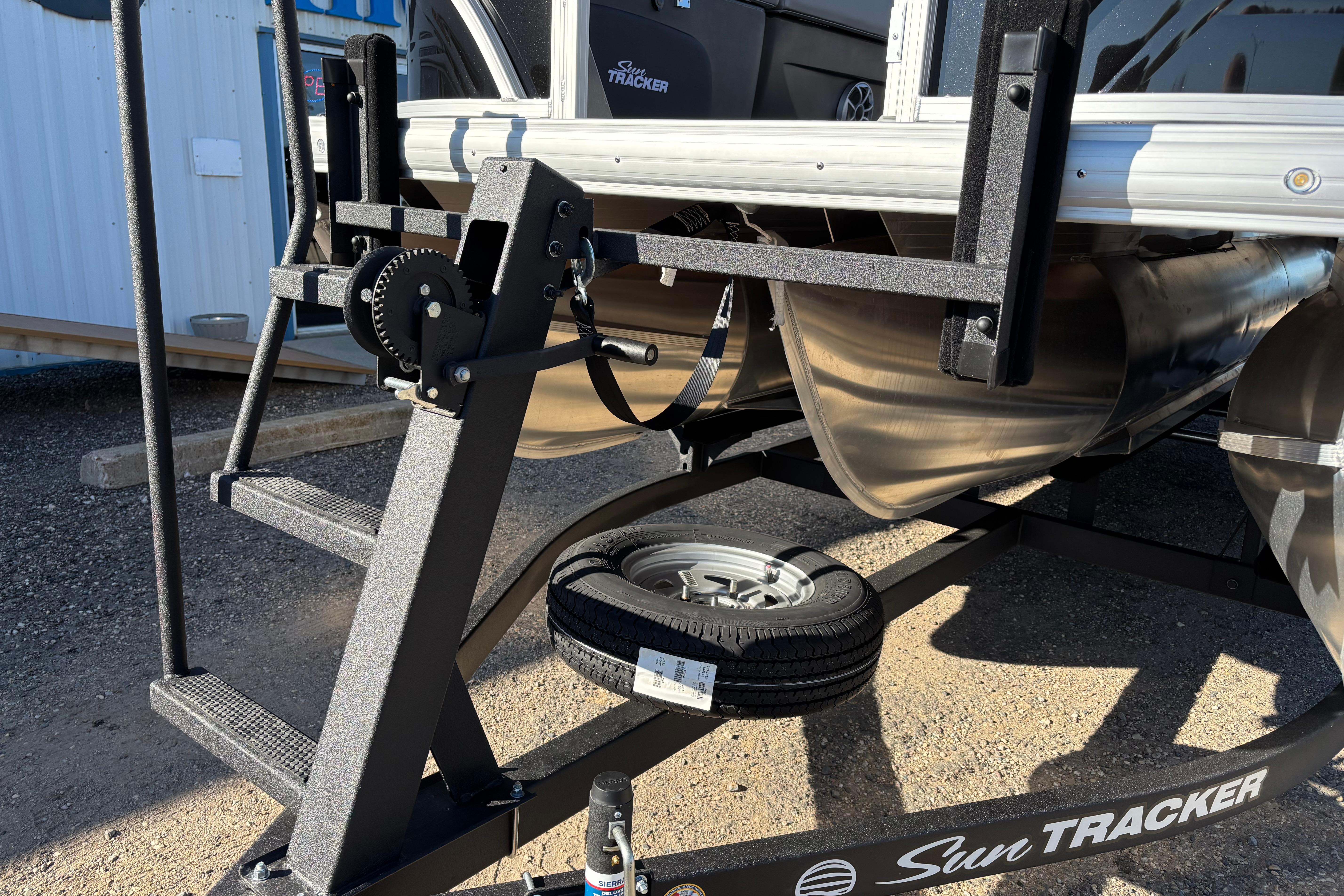 2026 Sun Tracker SportFish 22 XP3 pontoon boat on trailer, close-up view.
