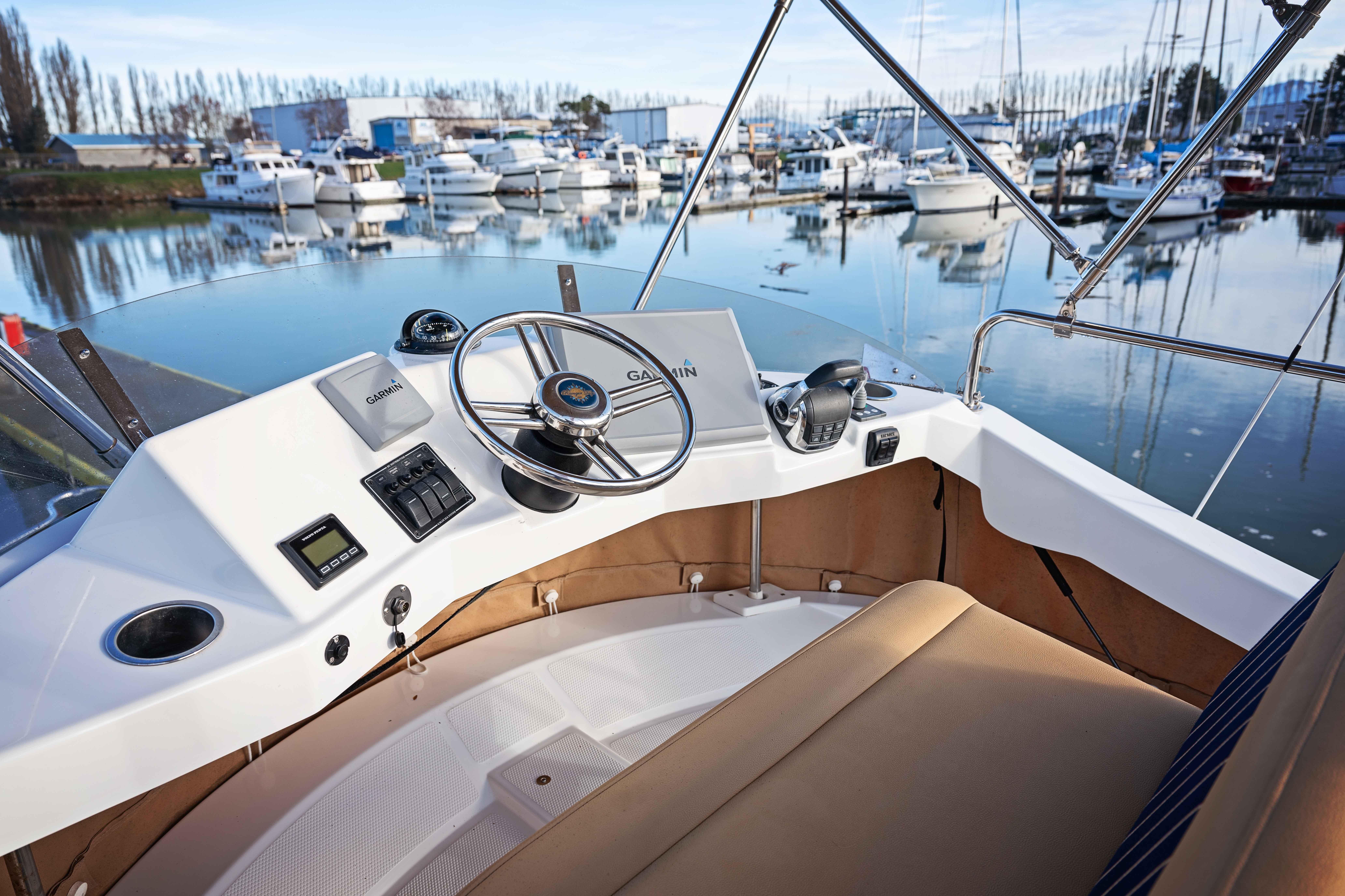 2014 Ranger Tug R-31 CB helm with marina view, featuring Garmin navigation system.