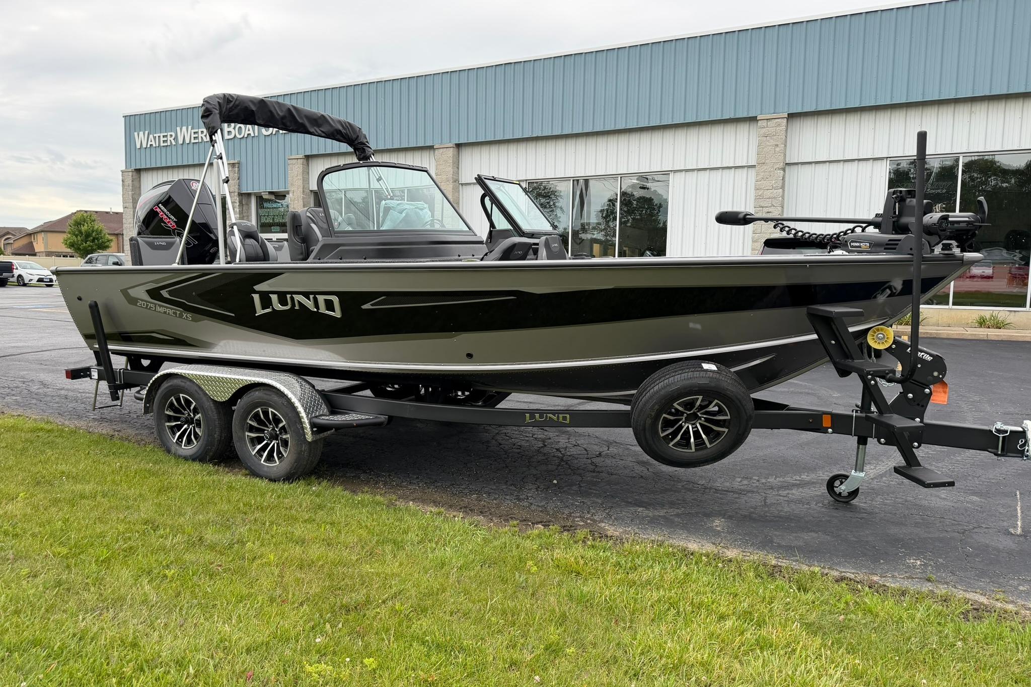 2027 Lund 2075 Impact XS boat on trailer outside dealership.