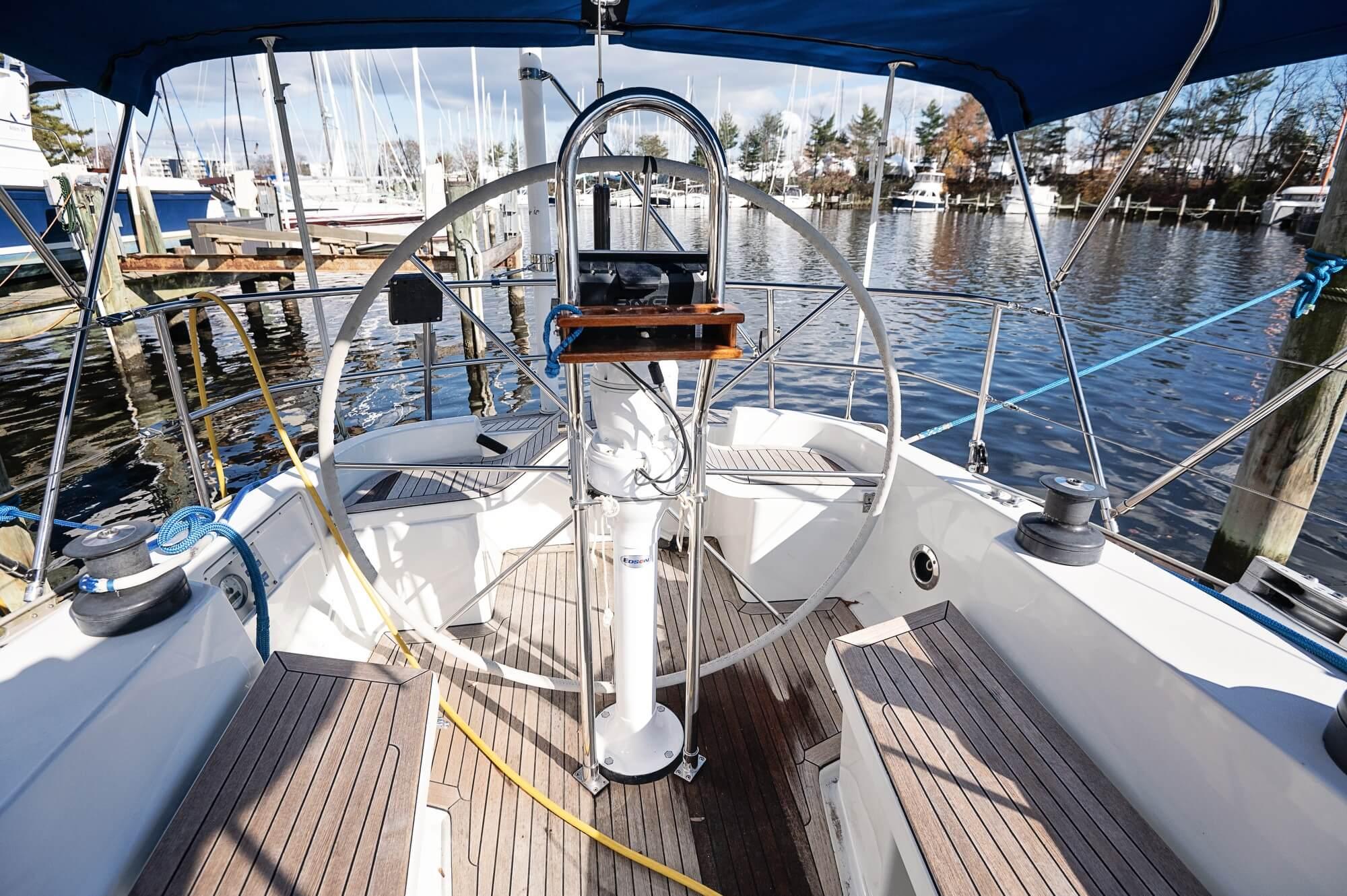 Cockpit of a 1977 Baltic 42 sailboat with wooden deck and steering wheel.