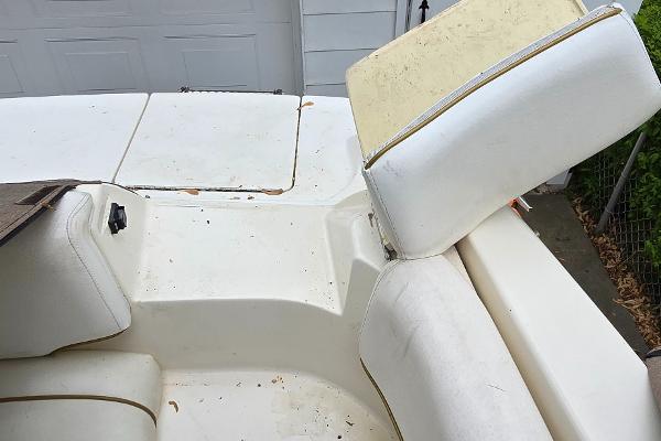 1999 Sea Ray 280 SS boat interior with white seating and storage compartments.