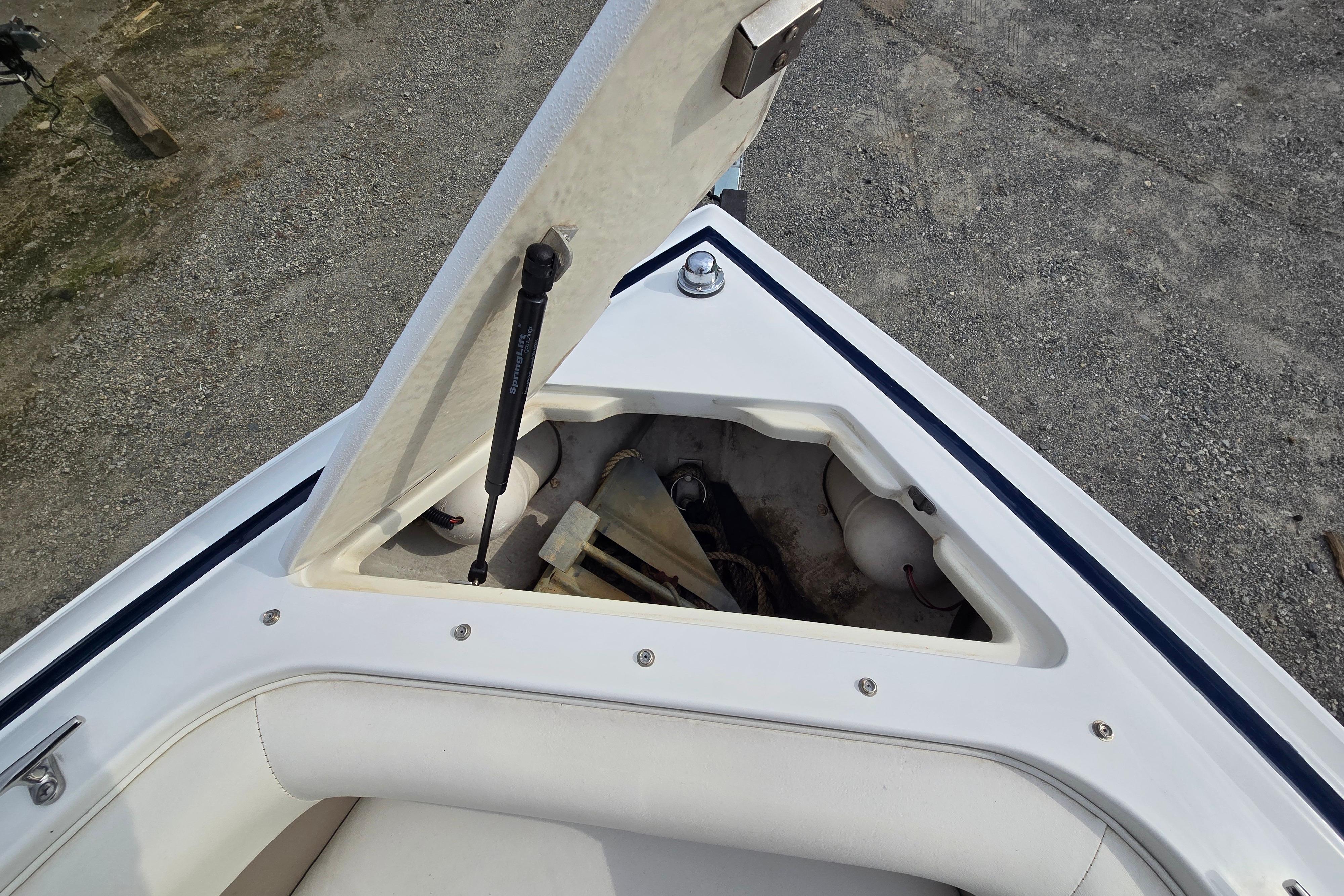 Open storage compartment on a 2000 Cobalt 246 boat, showing anchor and equipment.