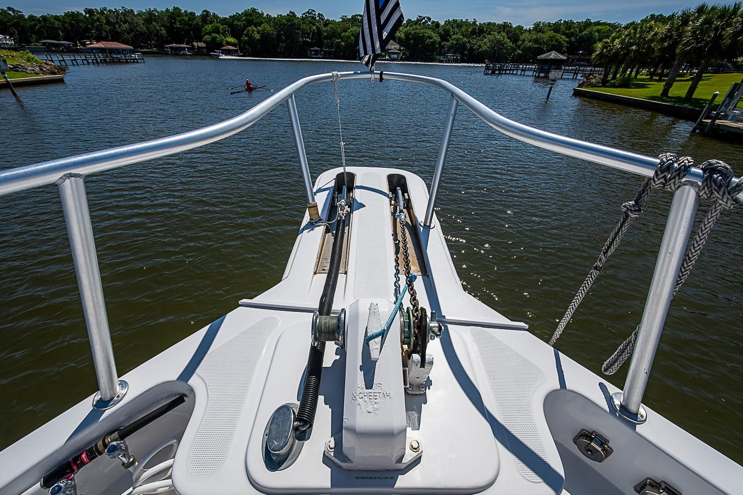 Bow view of 2003 Magna Marine Nova Scotia 47 yacht on a serene lake.