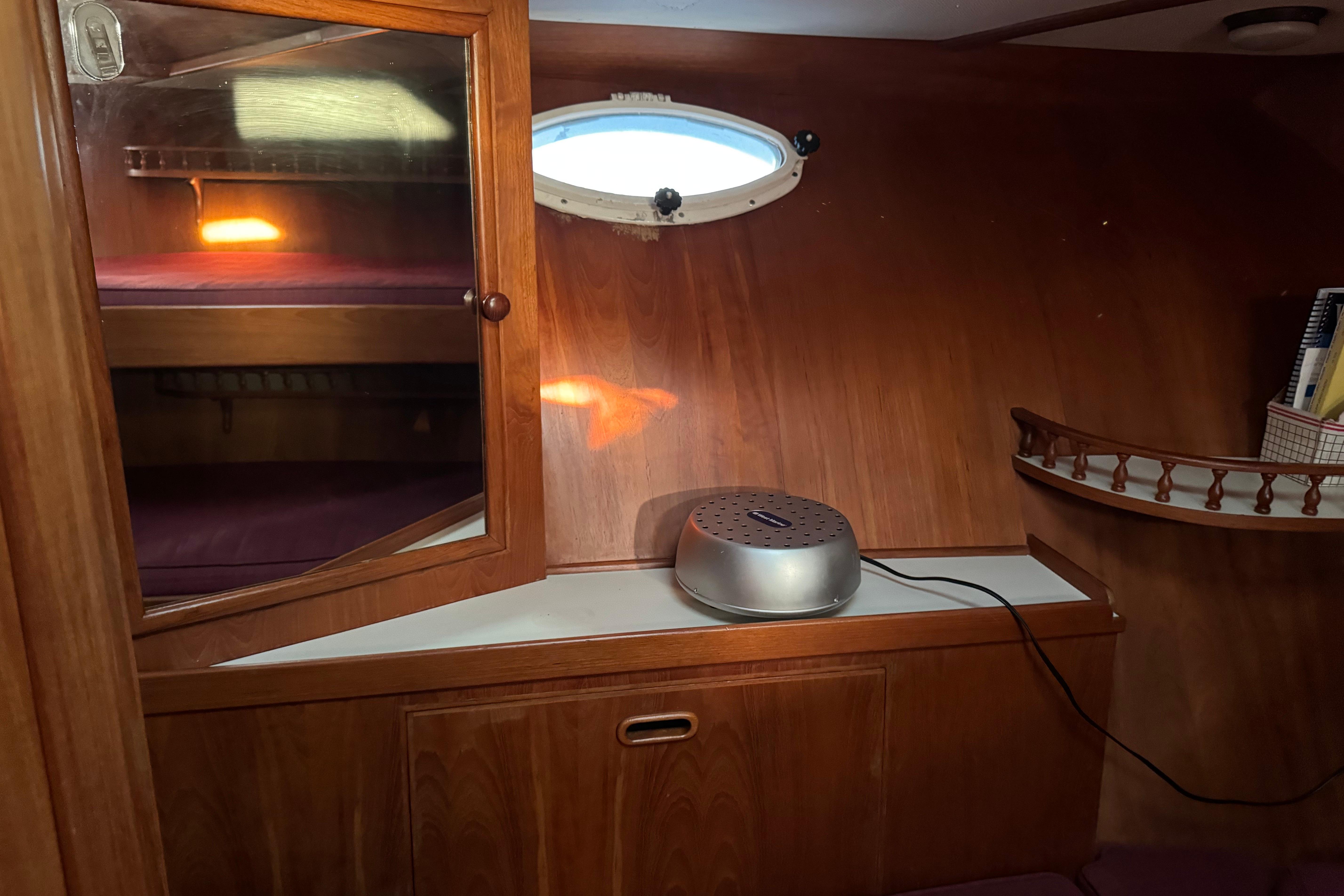 Cozy 1987 President 37 yacht cabin with wooden interior and porthole window.