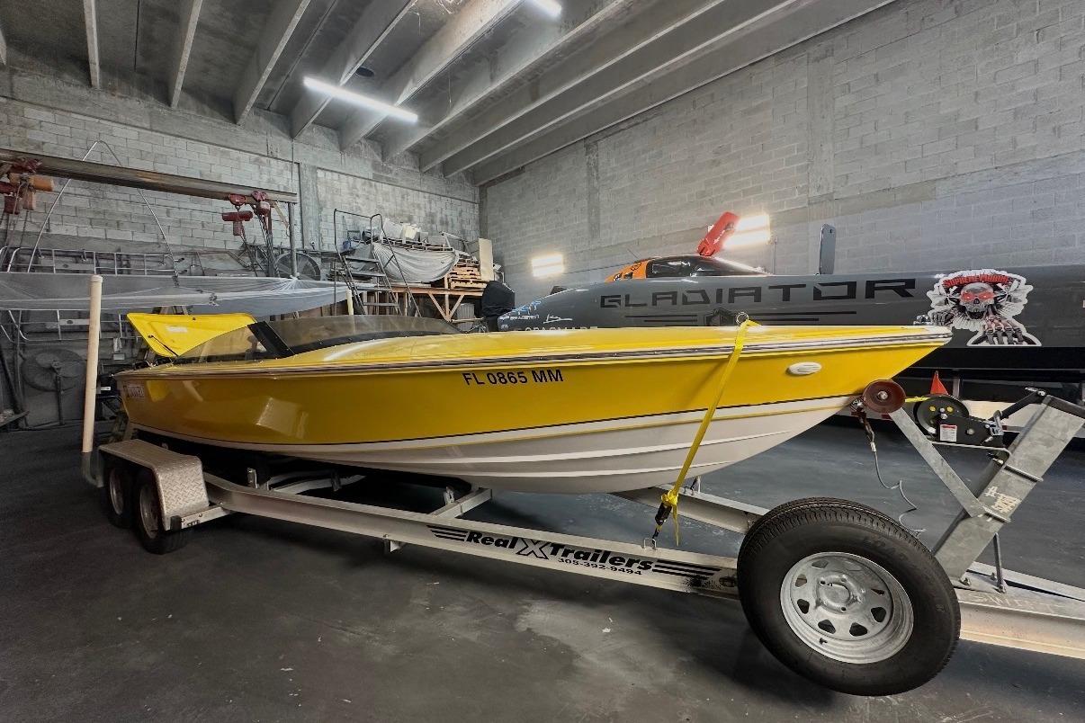 Yellow 2004 Donzi 22 Classic boat on trailer in a garage setting.