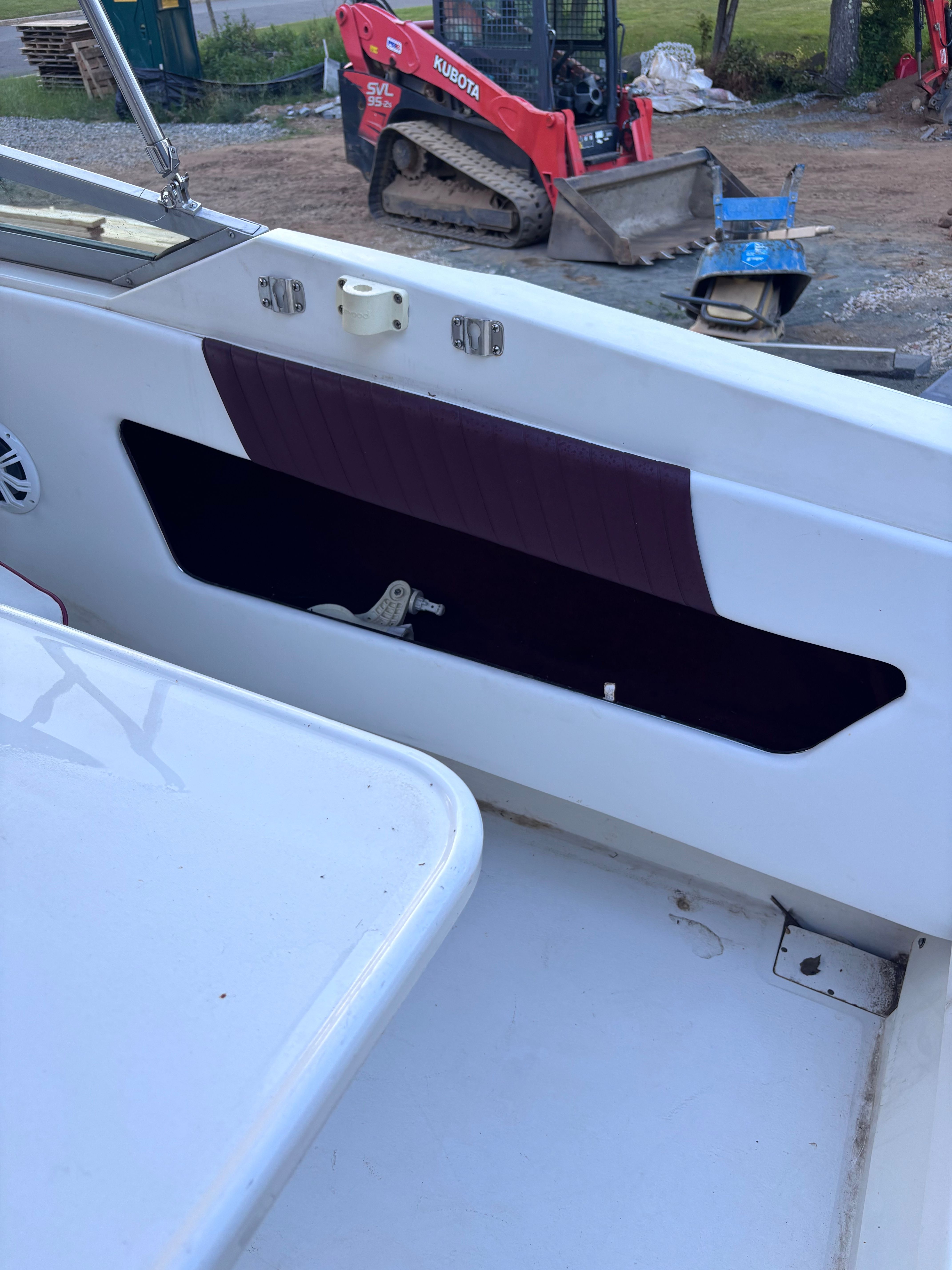 Part of a 1989 Sea Ray Sundancer cockpit with storage compartment and speaker.