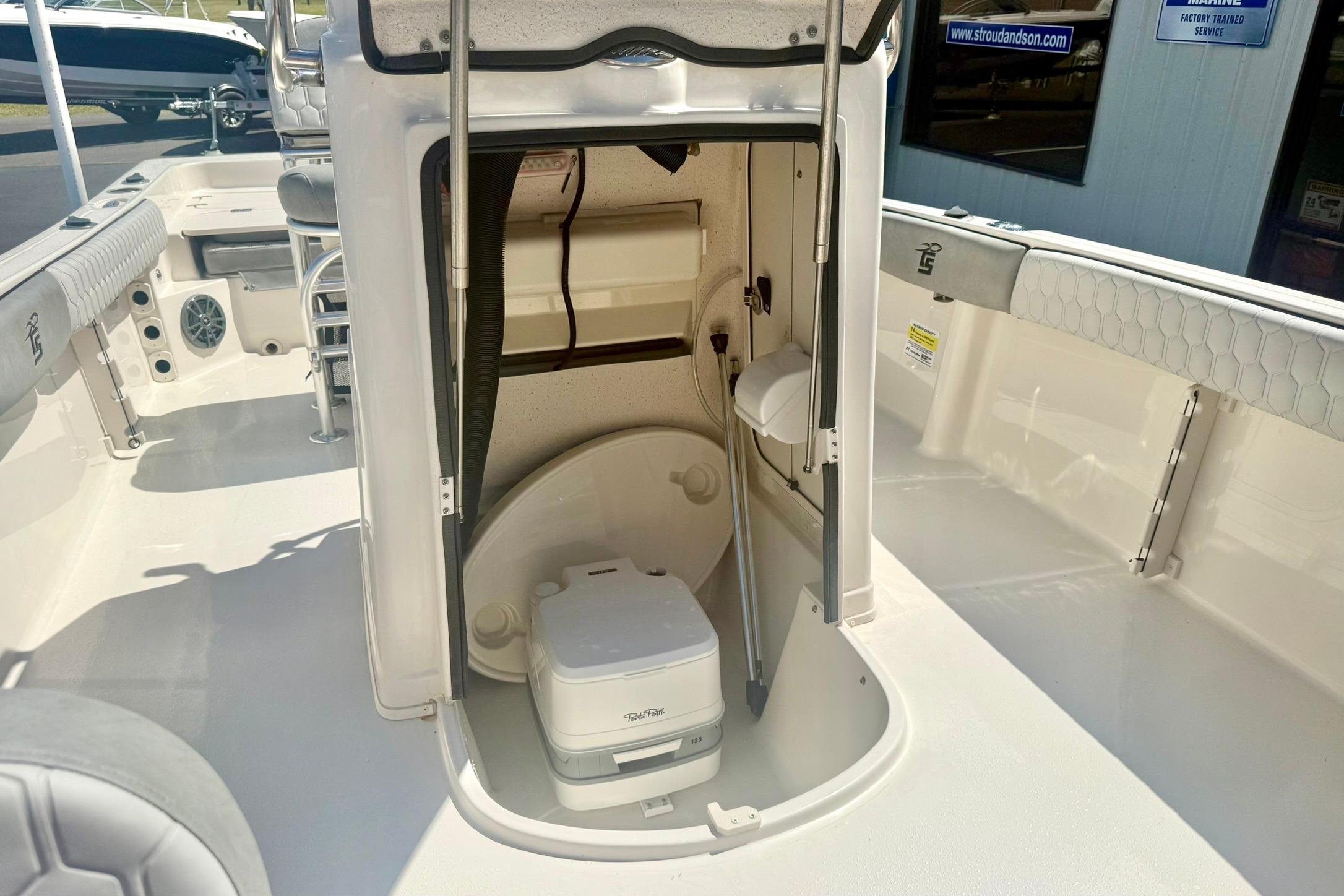 2026 Carolina Skiff 21 Ultra Elite boat interior with compact toilet and storage area.