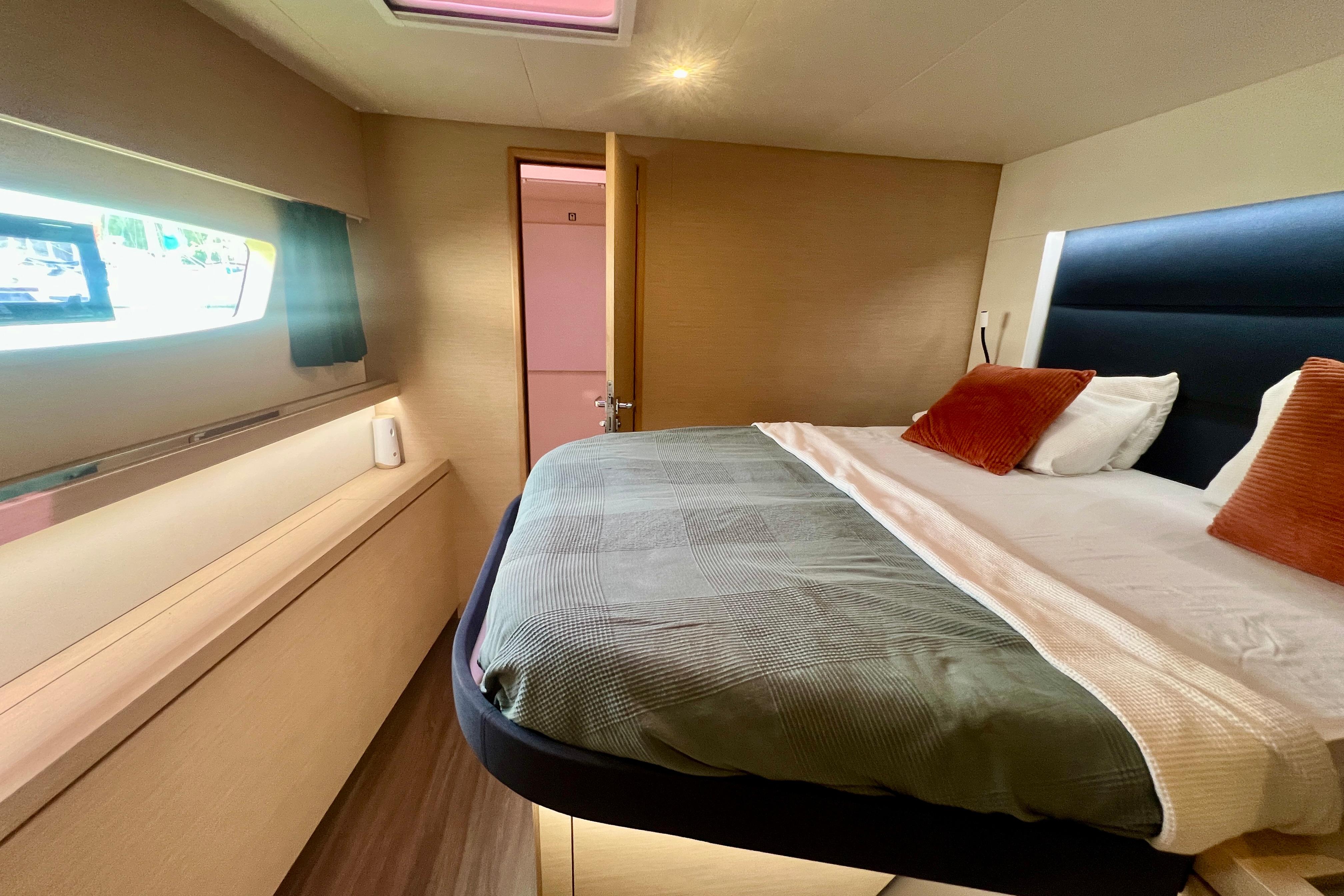 Luxurious cabin interior of 2018 Fountaine Pajot Saona 47 catamaran with cozy bed and window view.