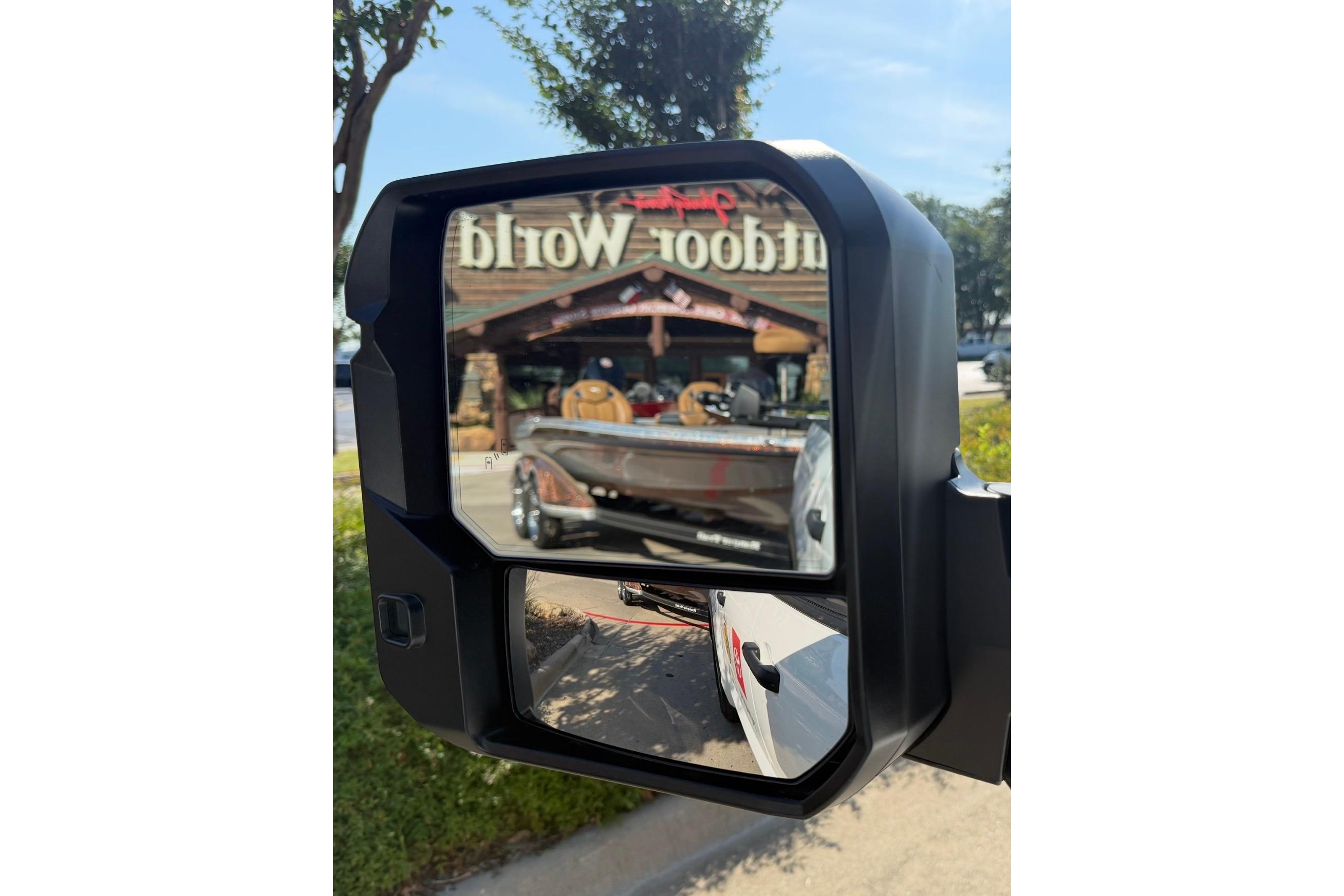 Side mirror reflection of a 2026 Ranger Z521R boat at outdoor store.