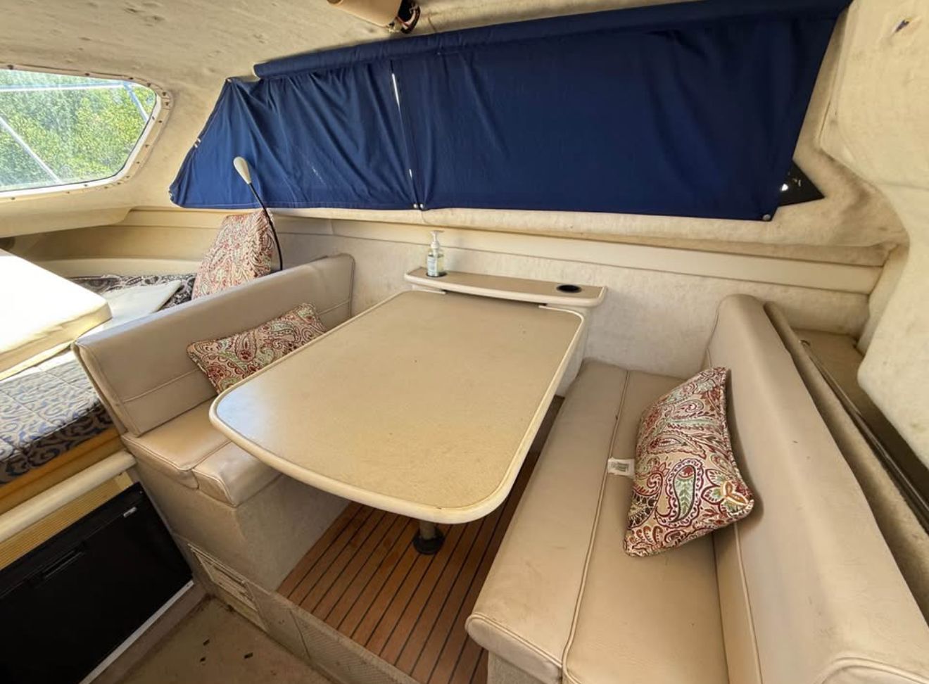 Interior of 2003 Bayliner 2452 Classic Cruiser with dining table and seating area.