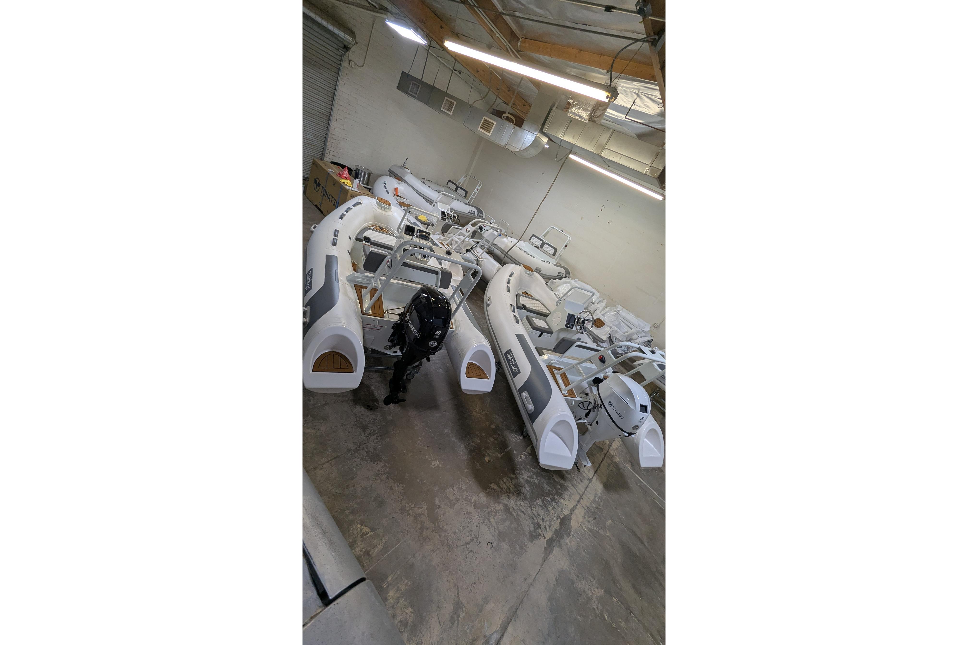 Warehouse with multiple 2027 Tide Craft San Juan 11 boats in storage.
