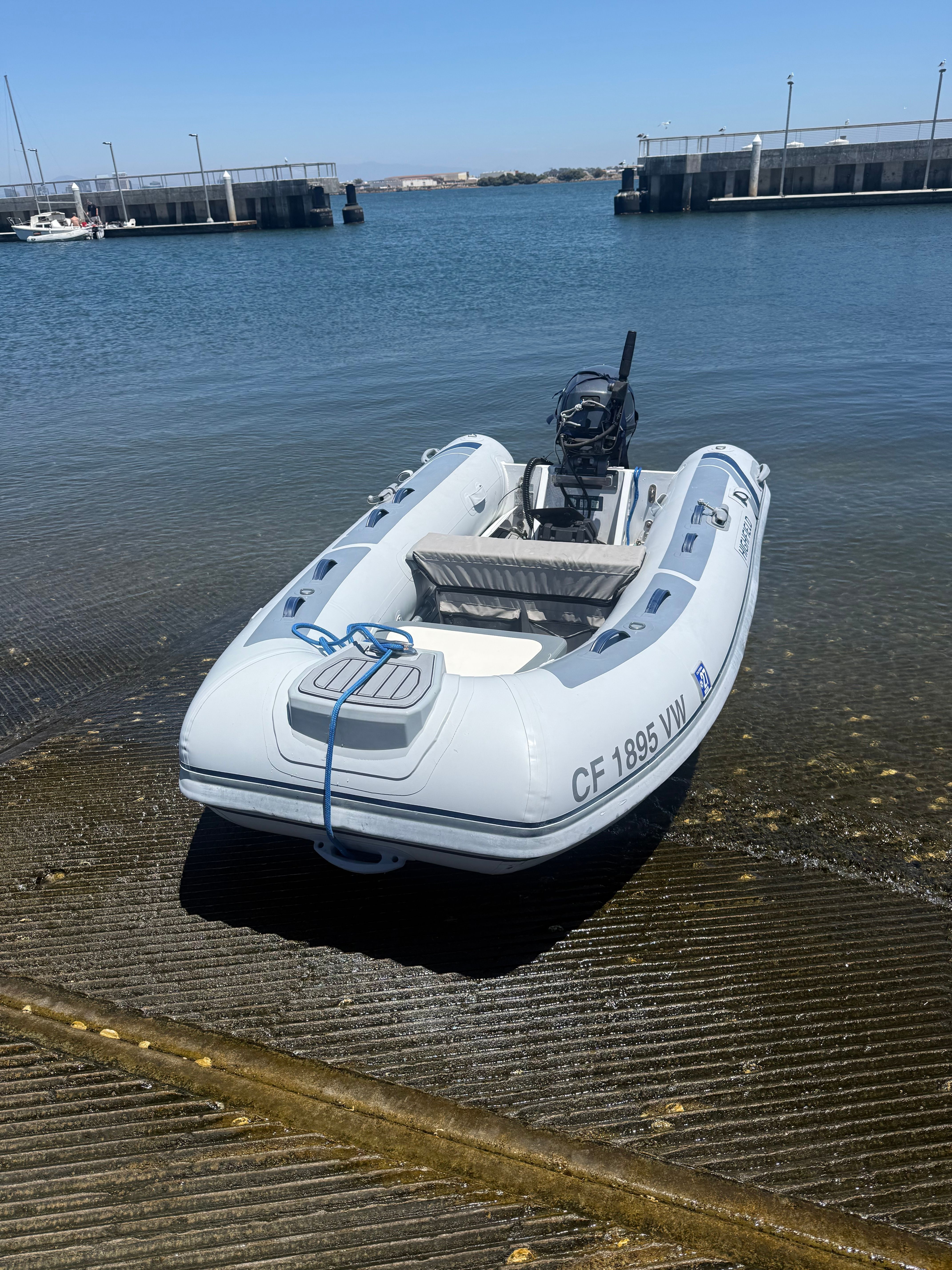 A Highfield Classic 310 inflatable boat is on a ramp by the water.
