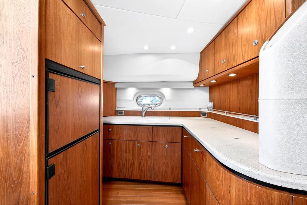 Luxurious 2006 Tiara Yachts 4300 Sovran kitchen with wood cabinetry and modern appliances.