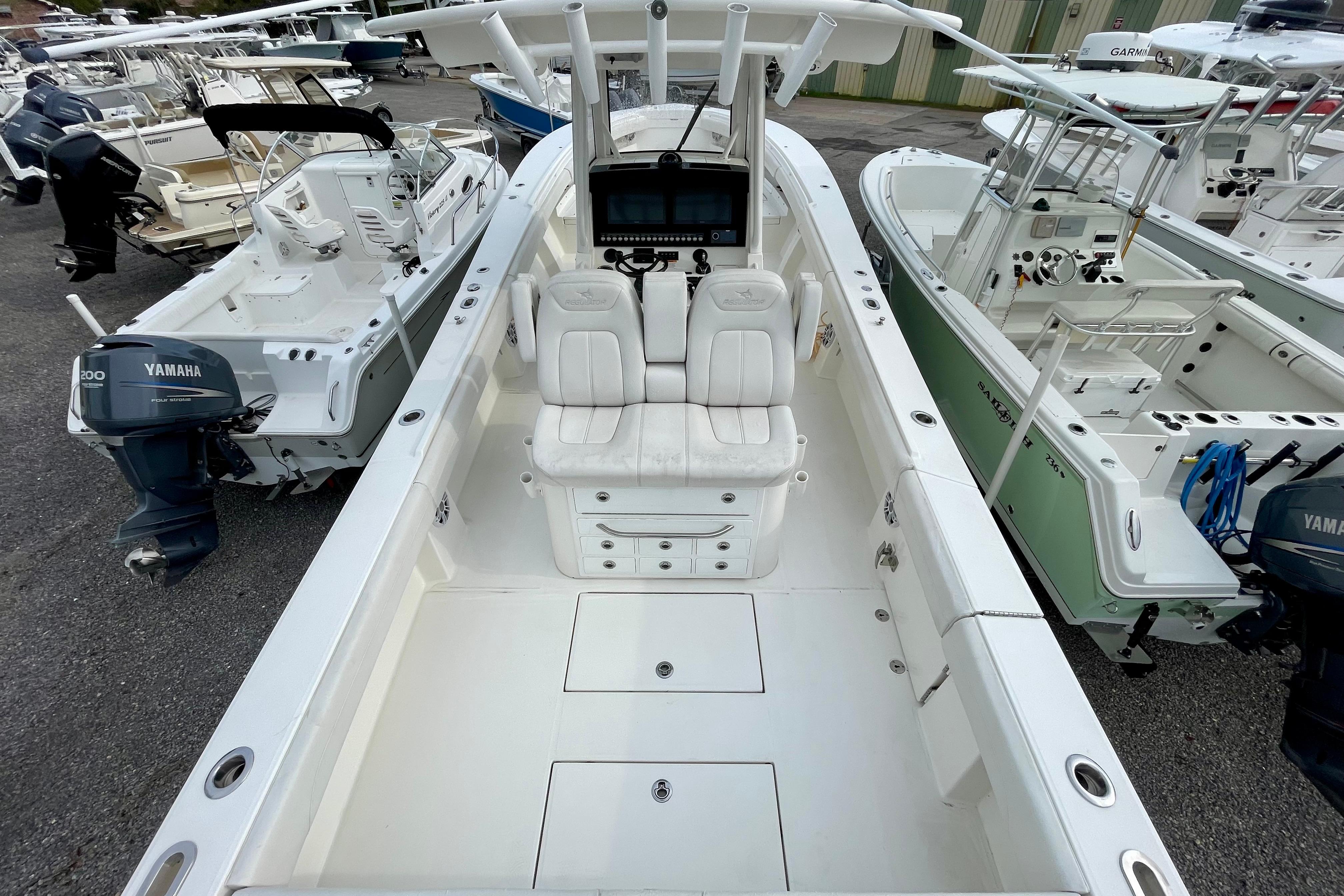 2023 Regulator 34 boat with dual seats and Yamaha outboard, docked among other boats.
