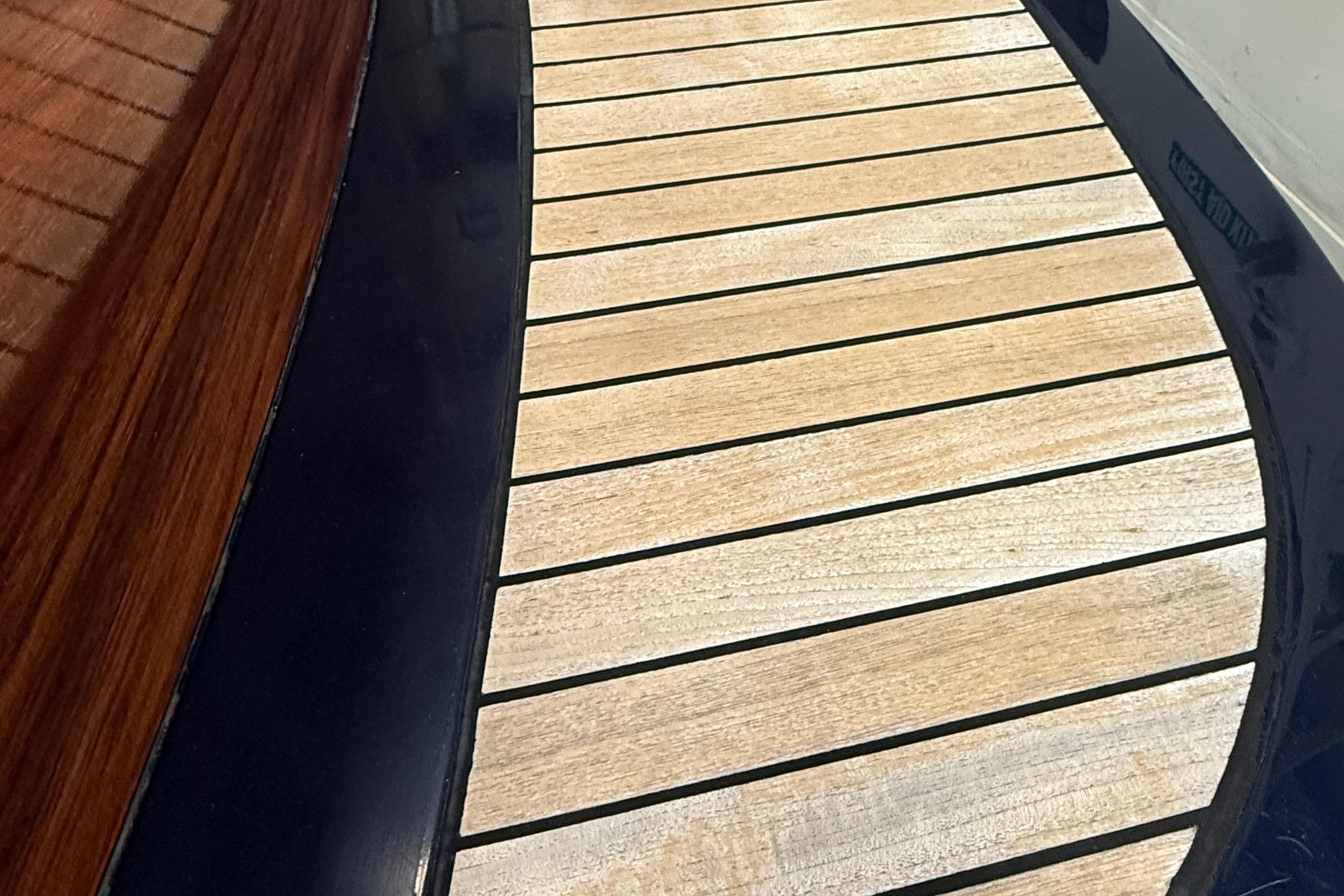 Teak deck detail of 2002 Hinckley Talaria 29C boat, showcasing elegant wood craftsmanship.