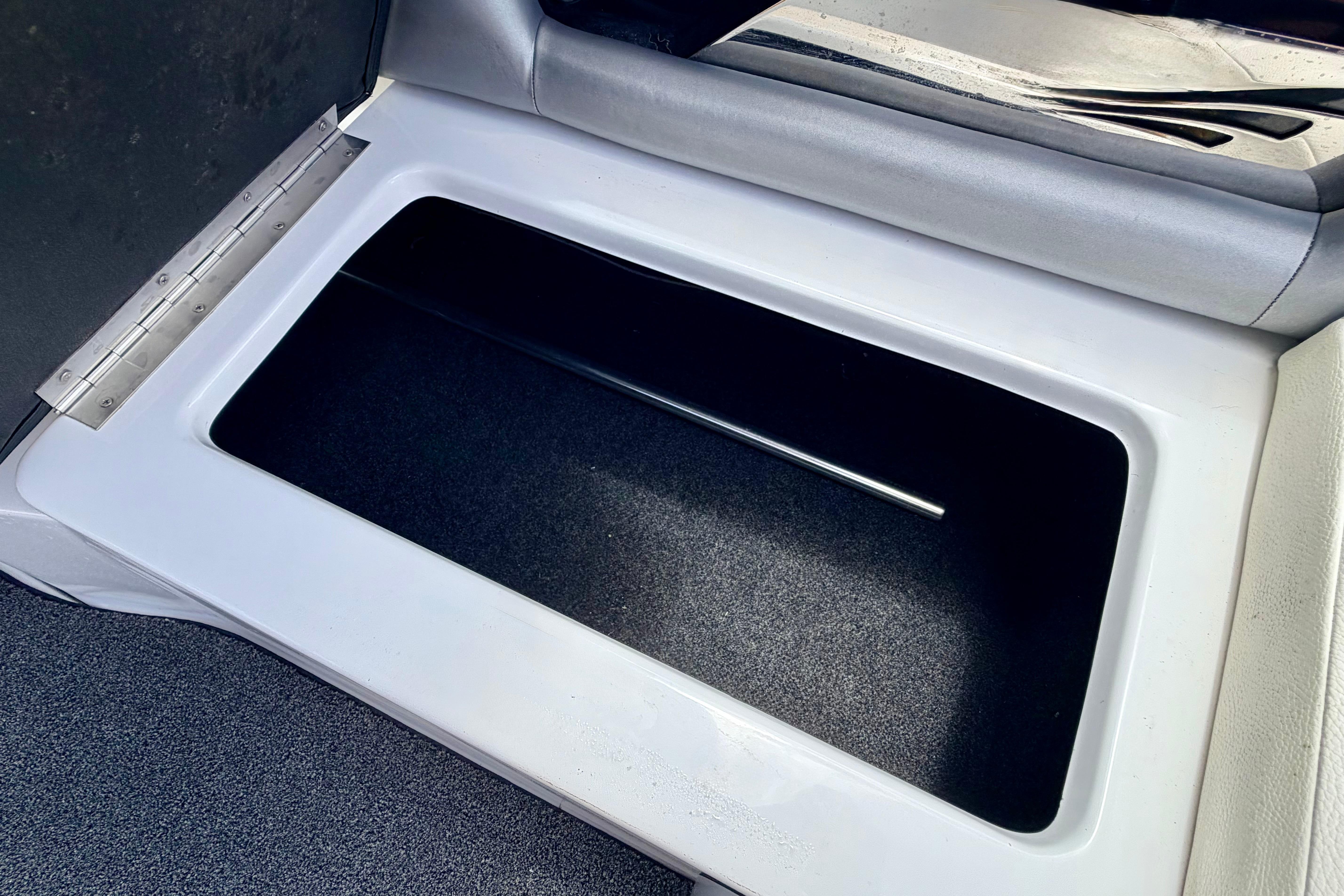 2014 Tigé R20 boat storage compartment with open lid, showcasing interior space.