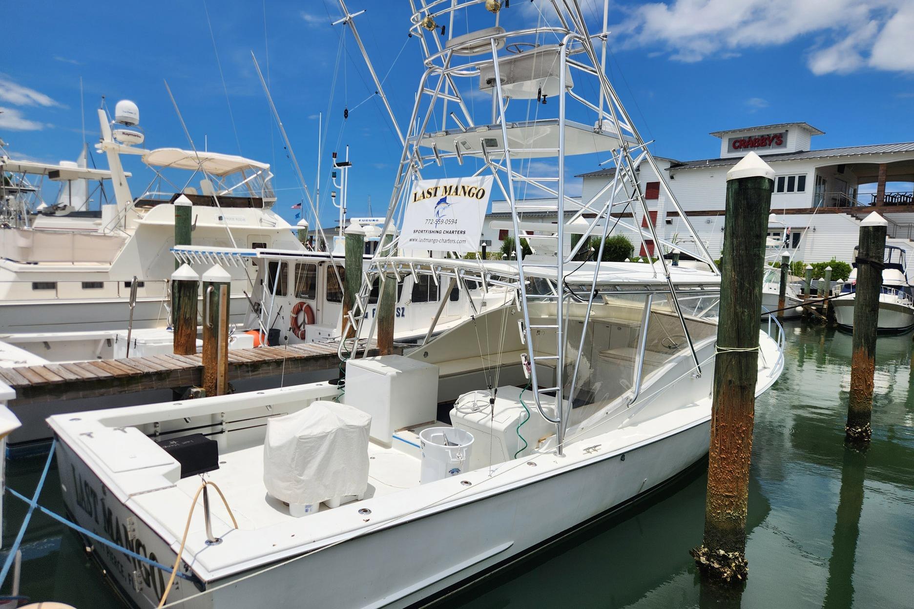 1987 Young Brothers Custom Sport Fish boat docked at marina under clear blue sky.