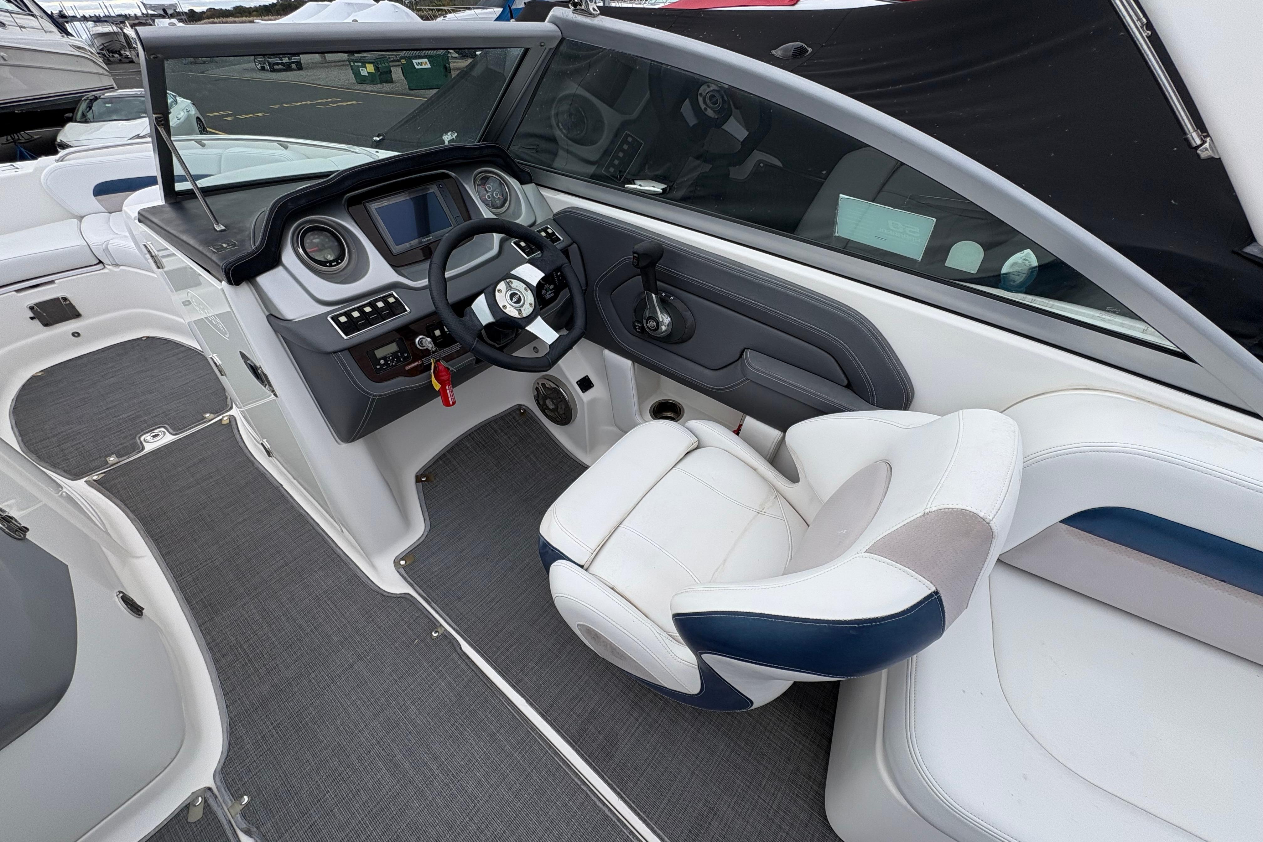 2015 Chaparral 264 Sunesta boat interior with steering wheel and captain's chair.