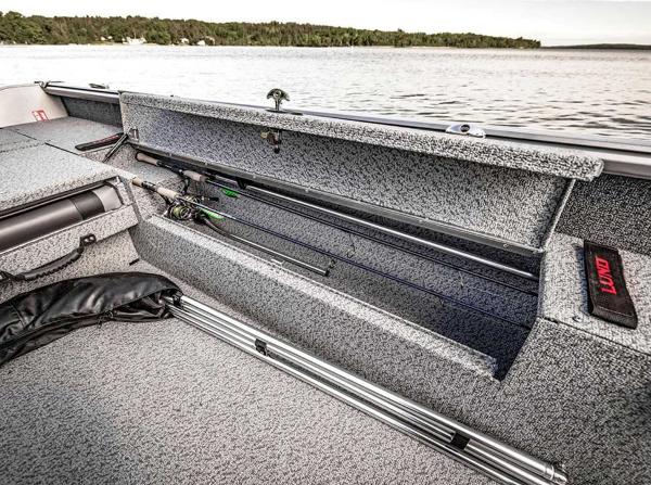 2026 Lund 1875 Impact XS boat with open rod storage by a lake.