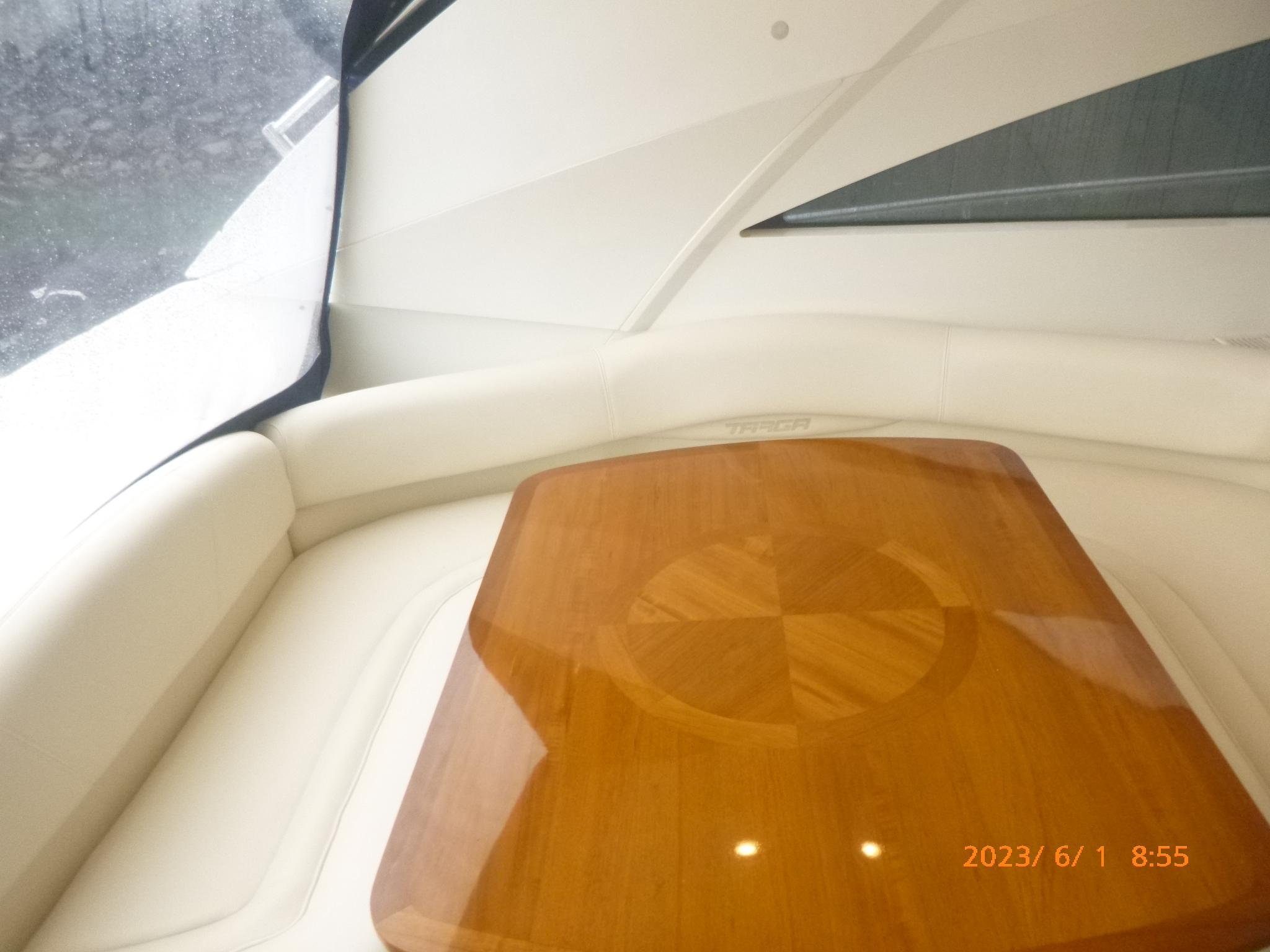 Interior of 2007 Fairline Targa 52 GT yacht with wooden table and white seating.