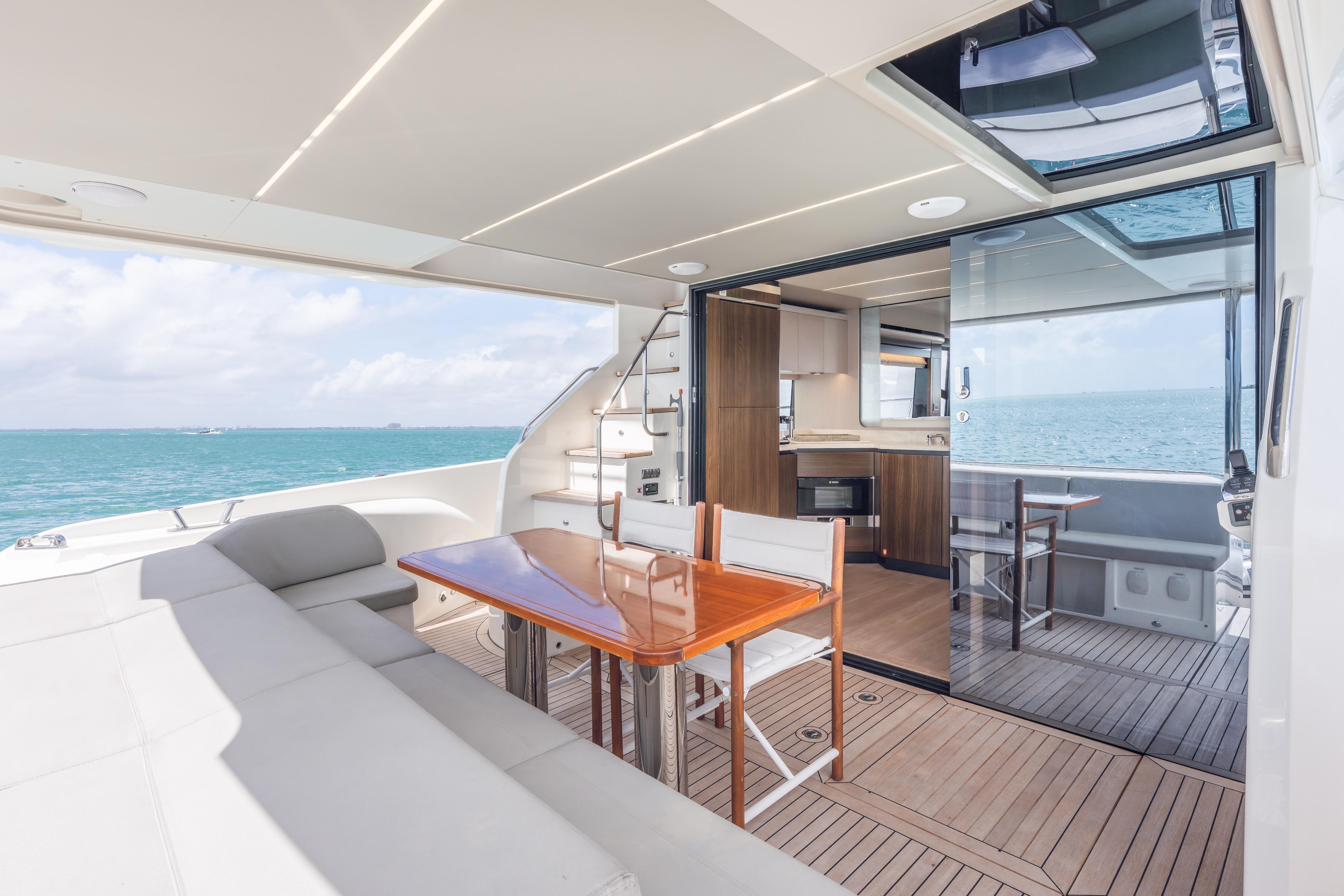Luxurious 2019 Absolute 58 FLY yacht interior with elegant dining area and ocean view.