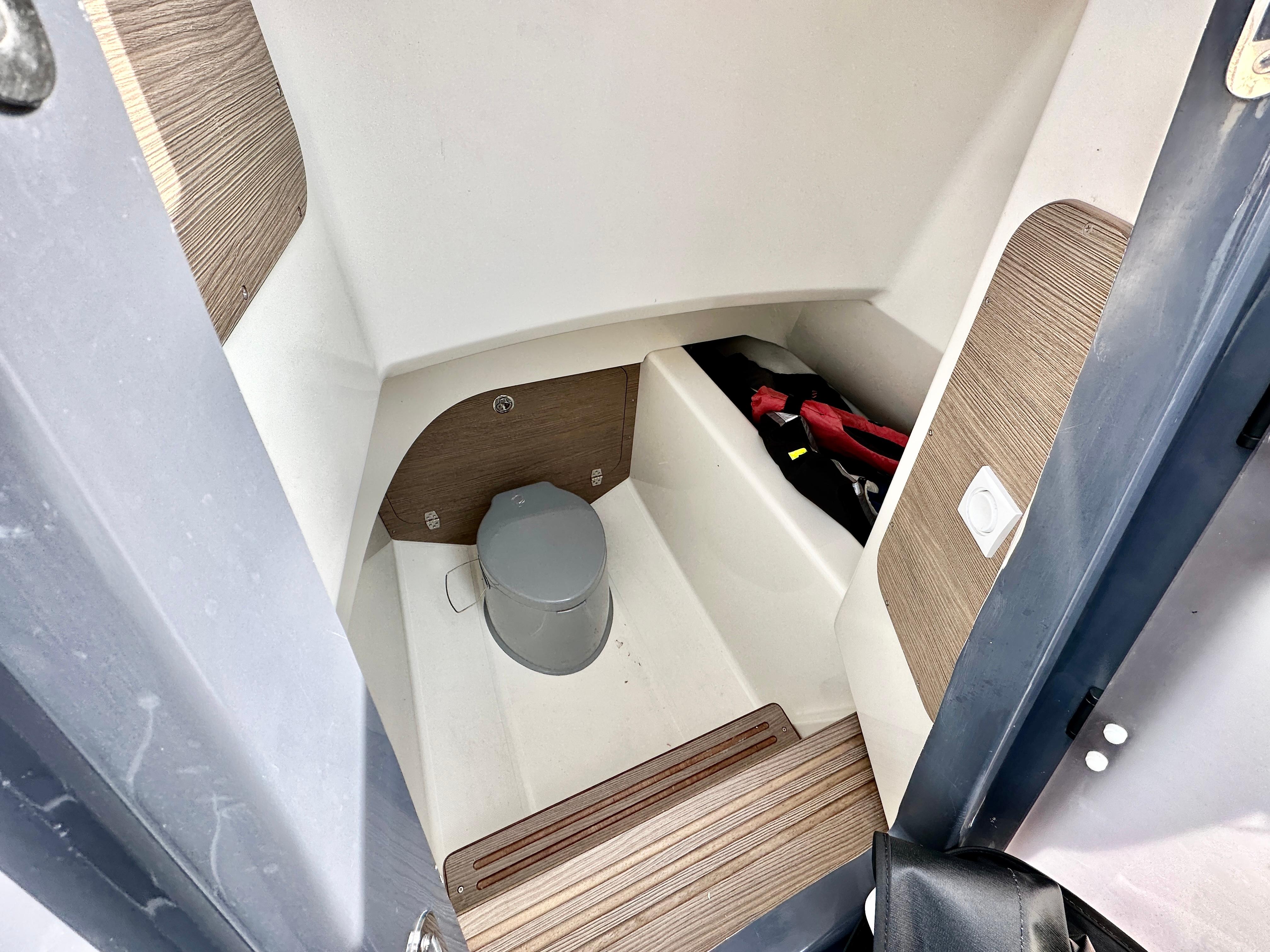 2021 Zodiac N-ZO 760 boat interior with compact toilet and storage area.