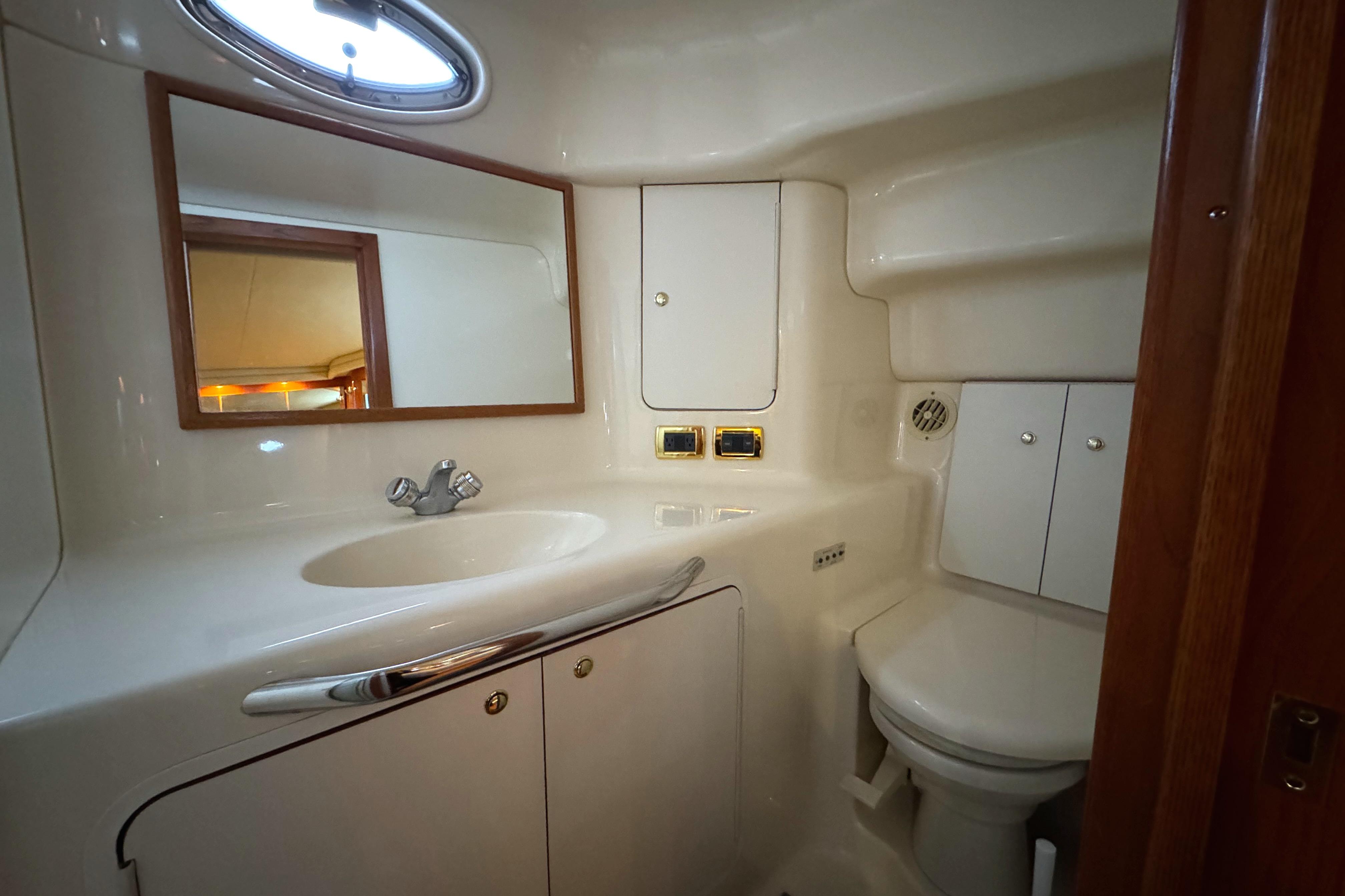 2001 Sea Ray 420 Aft Cabin bathroom with sink, mirror, and storage cabinets.