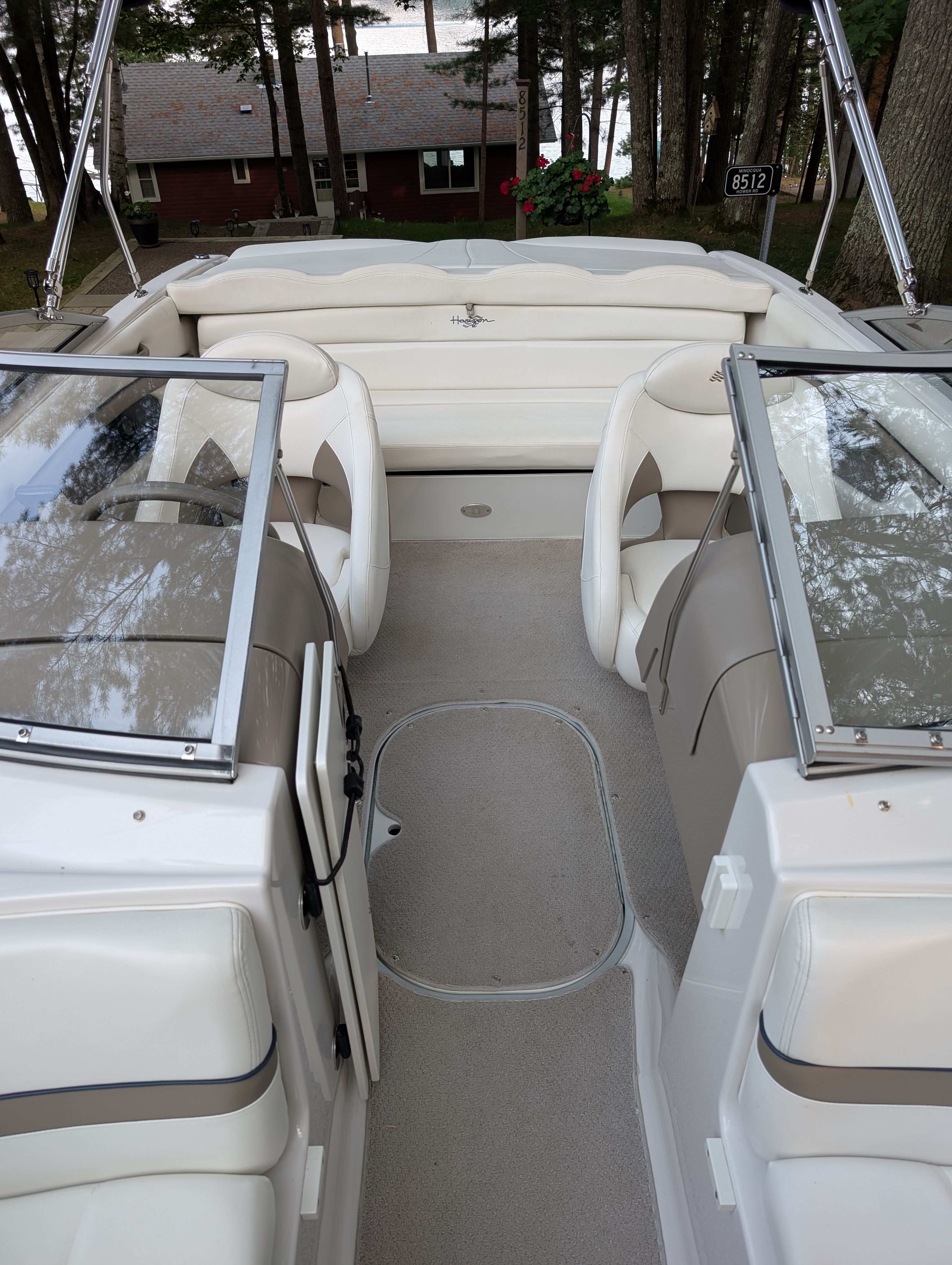 Interior view of a 2004 Four Winns 190 Horizon with beige seating and glass windshields.