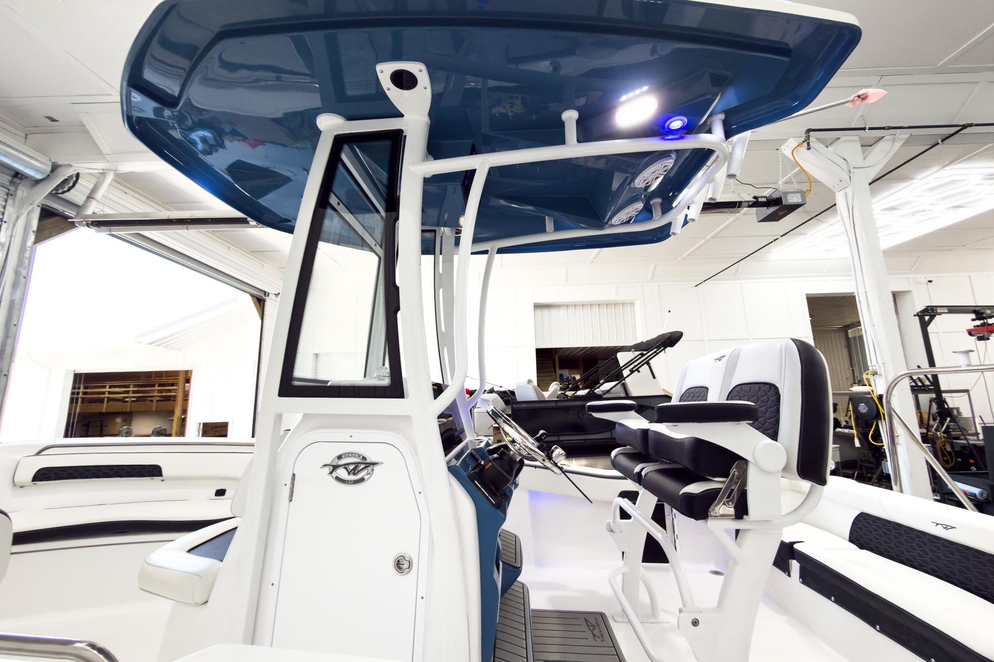 The image shows the cockpit of a 2026 Tidewater 220 LXF boat in a showroom.