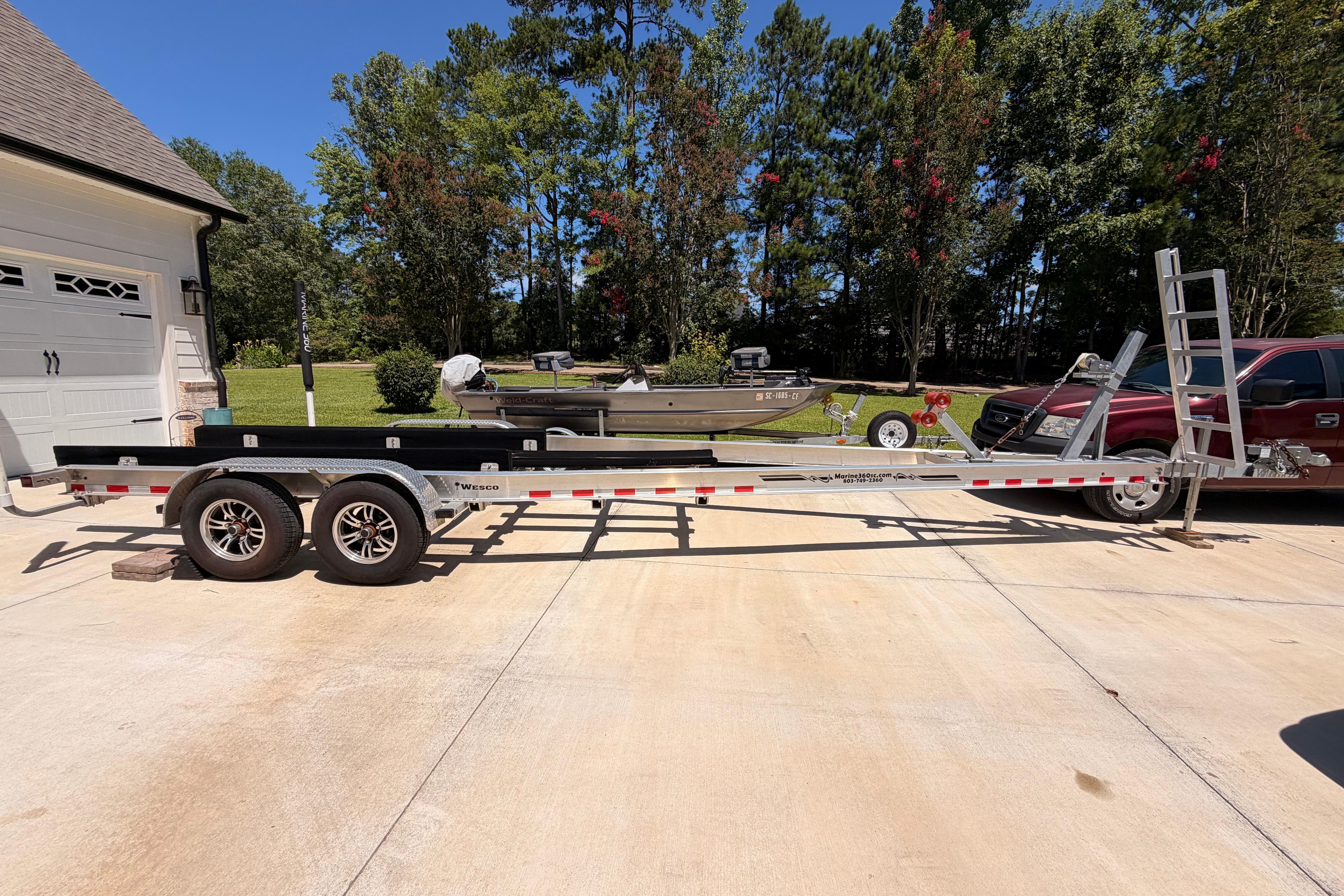 Trailer for 2024 Sea Hunt Gamefish 27 Coffin Box parked on driveway.