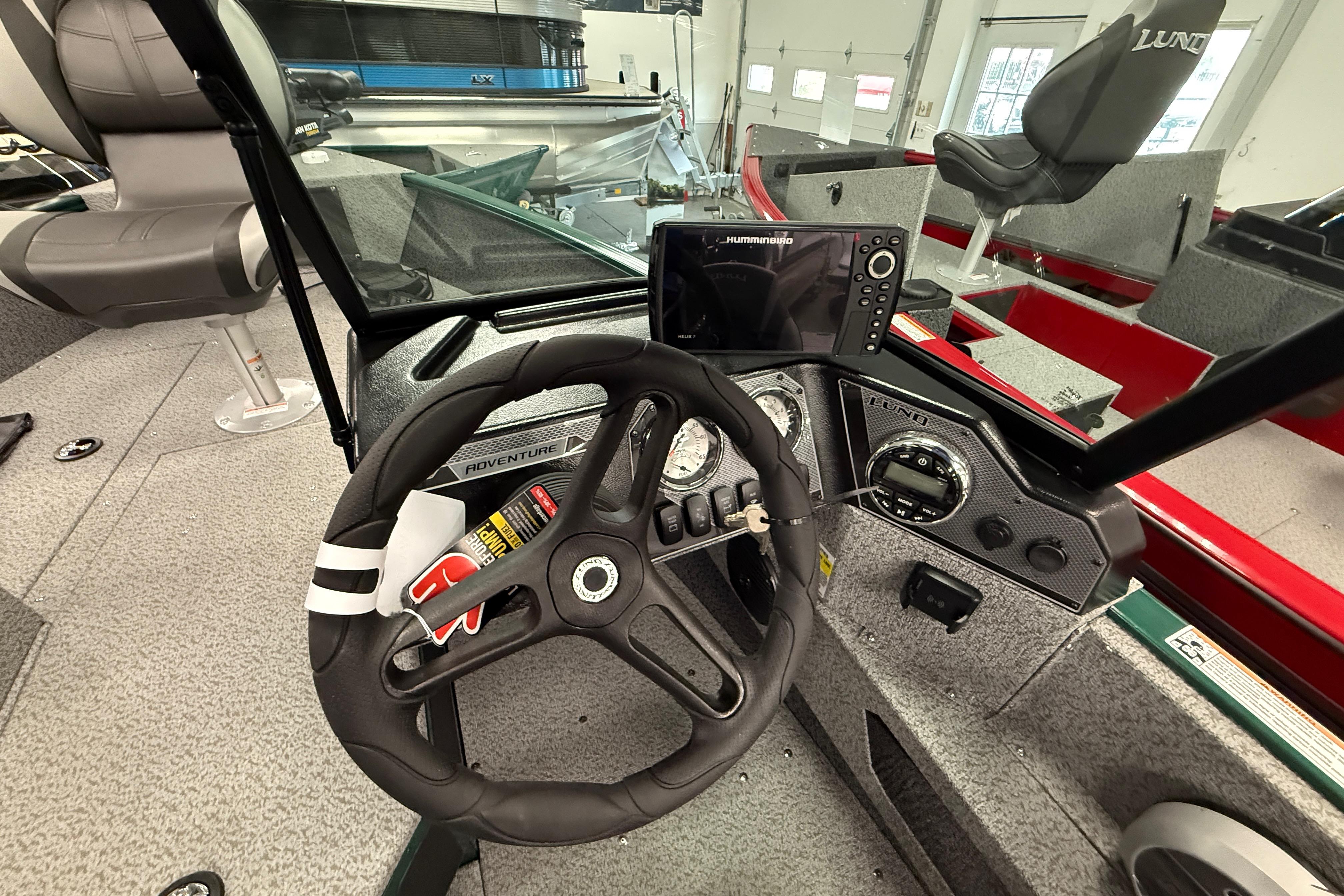 2026 Lund 1775 Adventure Sport boat interior with steering wheel and navigation system.