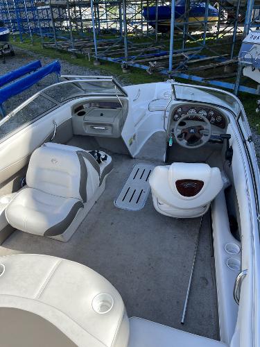2005 Crownline 180 BR boat interior with seating and dashboard, parked in storage area.