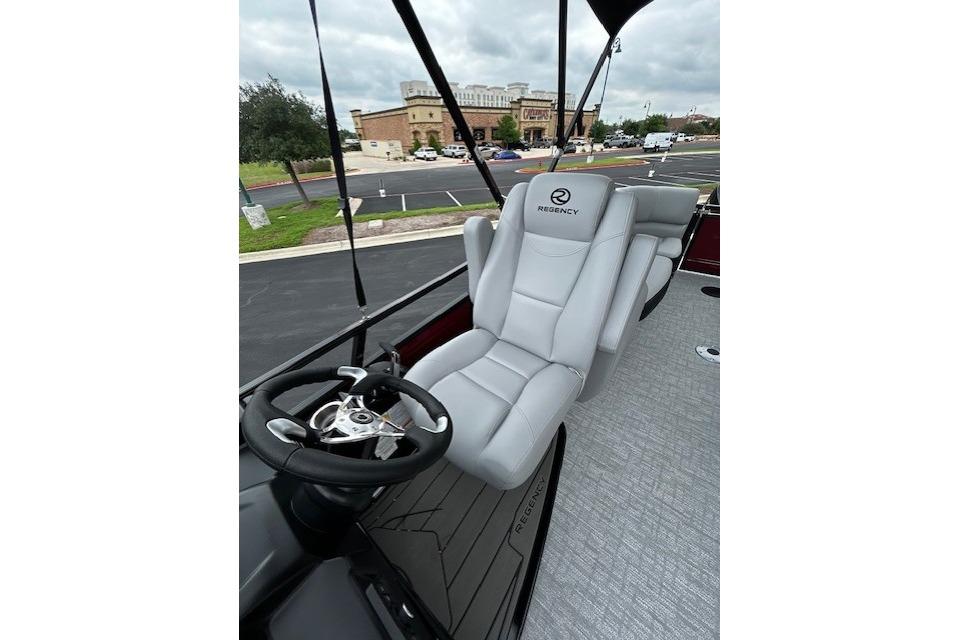 2026 Regency 250 DL boat interior with plush captain's chair and steering wheel.