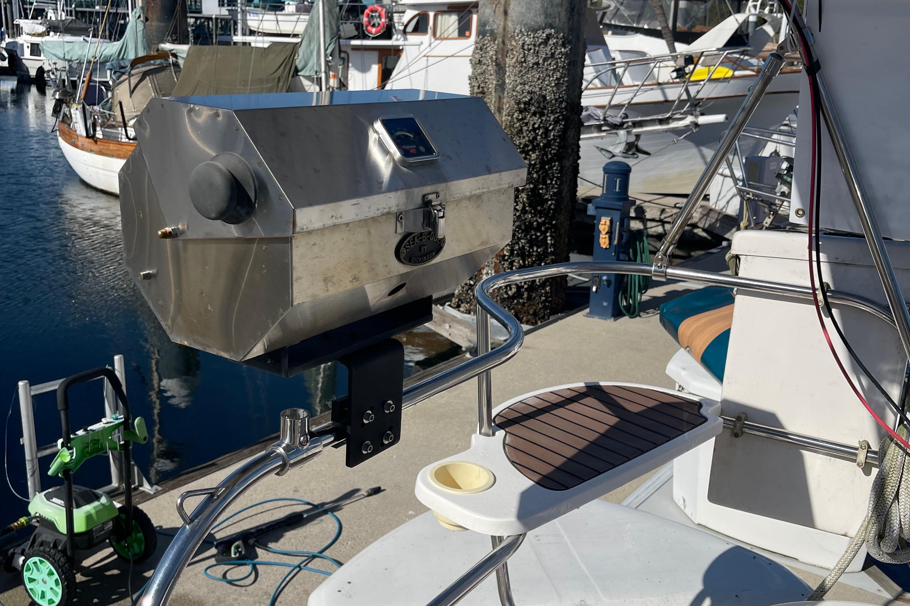 Stainless steel grill mounted on a 2008 Hunter 49 sailboat at a marina.