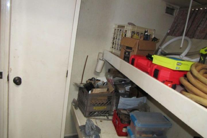 Storage area on a 1973 Chris-Craft 55 Commander with shelves and various tools.