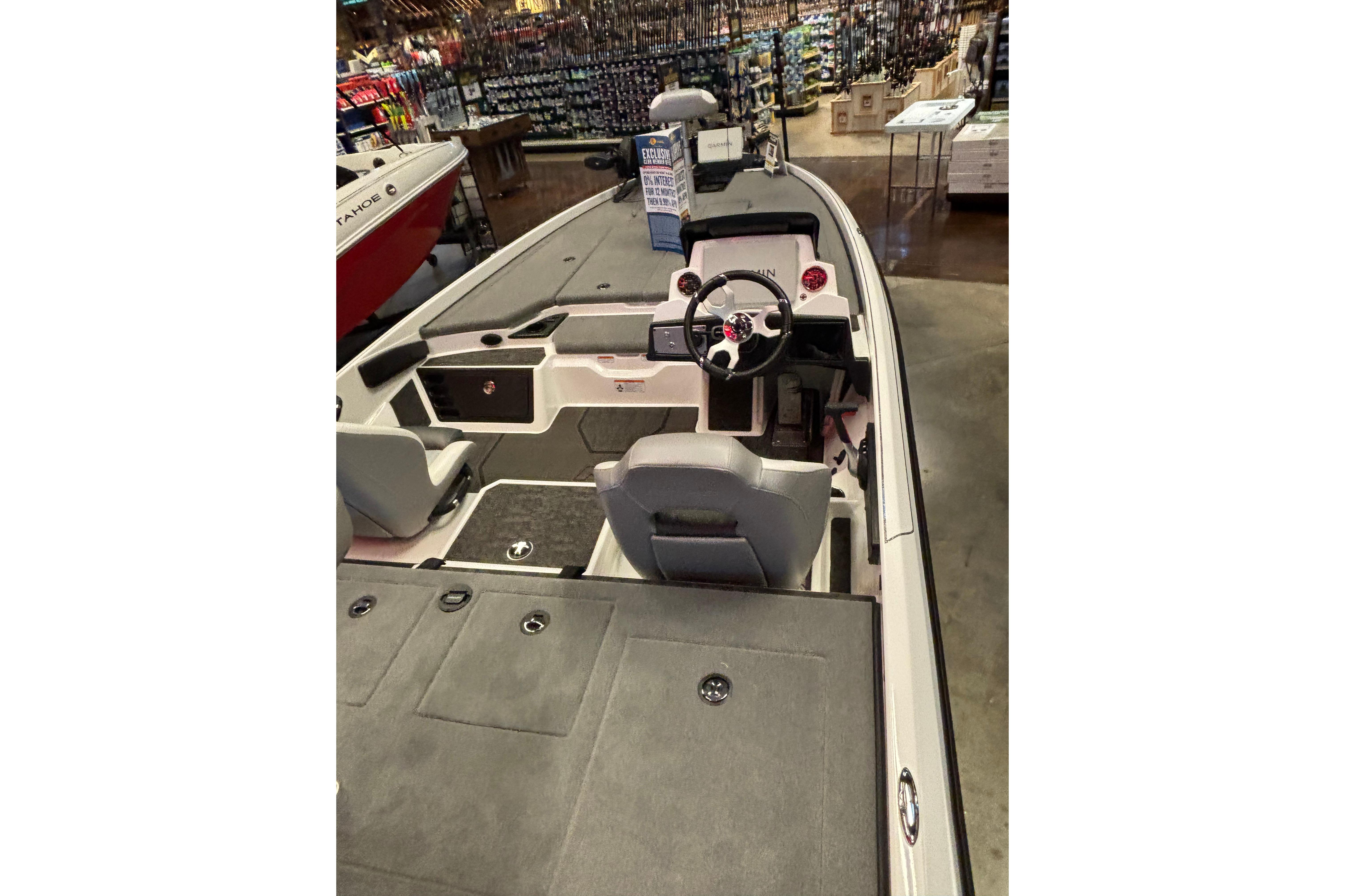 2026 Nitro Z21 XL Pro boat interior with steering wheel and seating in showroom.