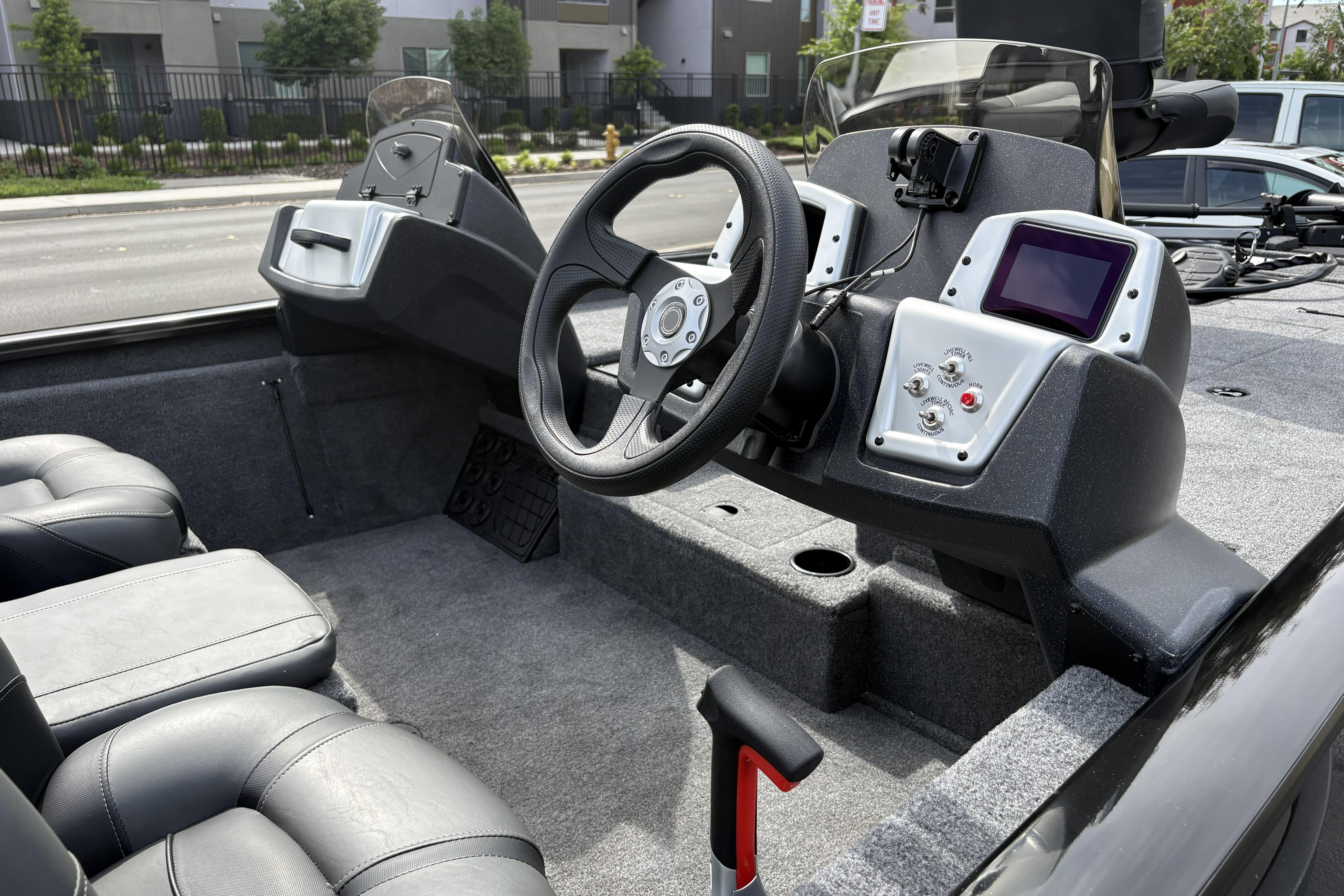 Interior of 2026 Tracker Pro Team 195 boat with steering wheel and control panel.