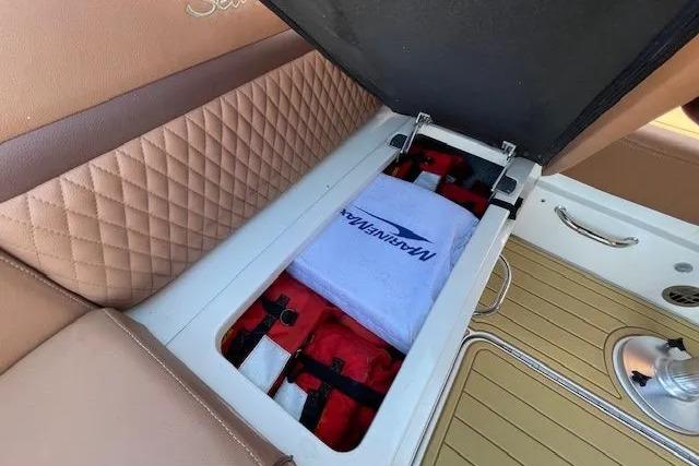 Storage compartment on 2016 Sea Ray Sundancer 510 with life jackets and towel.