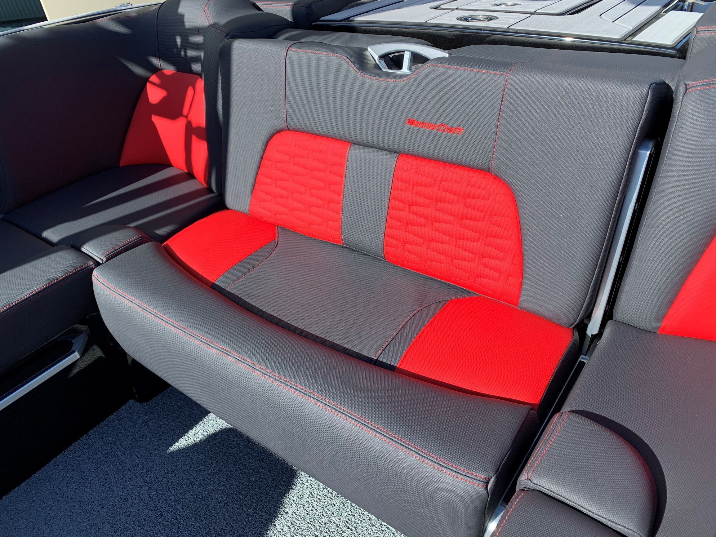 Rear seat of a MasterCraft X24 boat with gray and red upholstery.