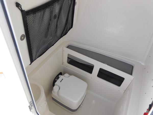 2024 Sailfish 242 CC boat interior with portable toilet and storage net.