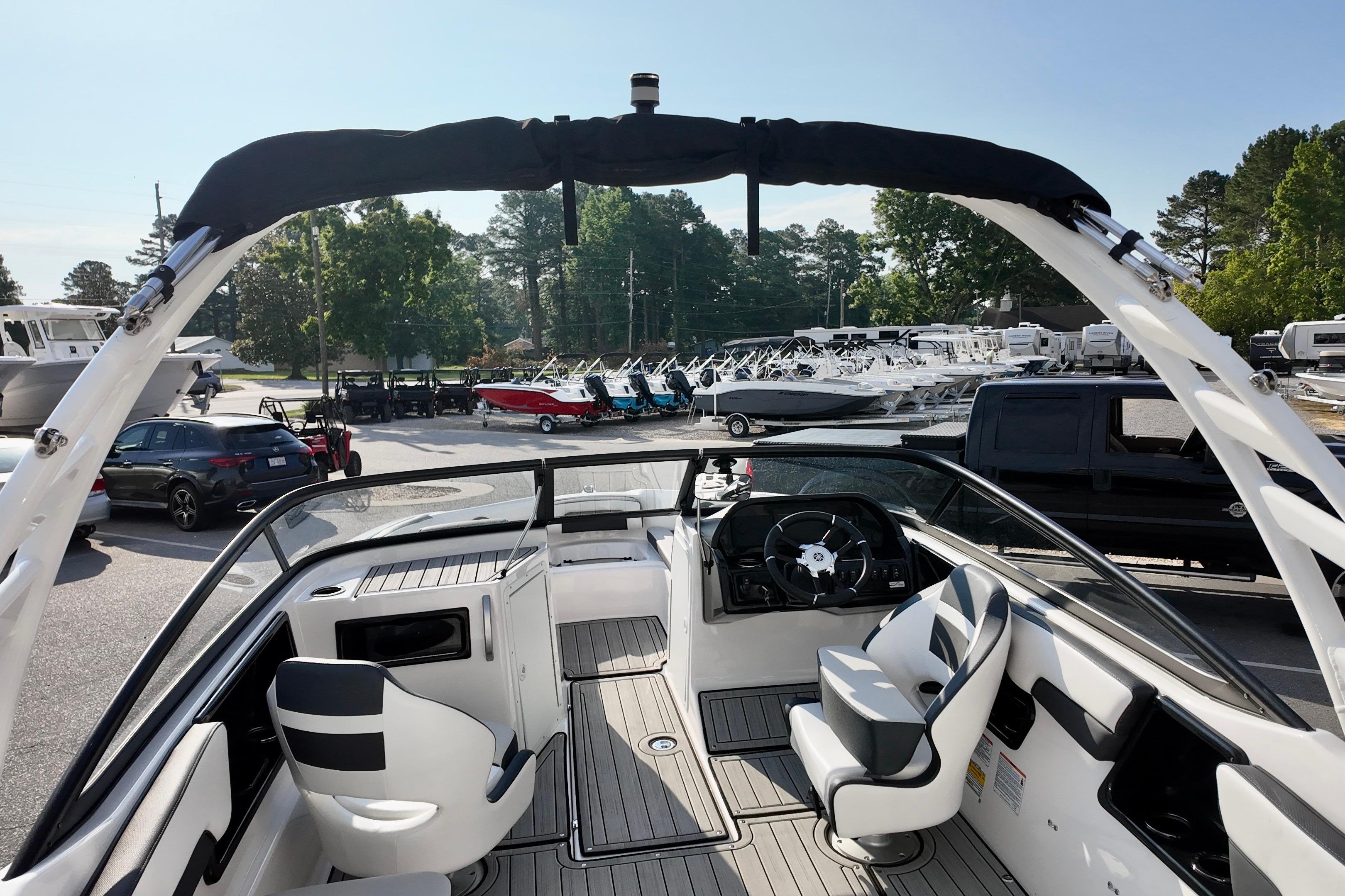 2023 Yamaha 195S boat interior with sleek seating and modern dashboard, parked outdoors.