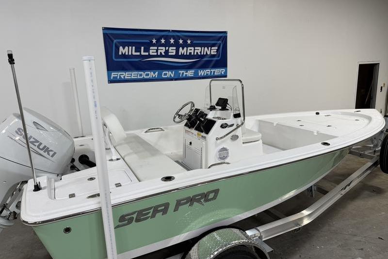 2026 Sea Pro 172 Bay boat in showroom, featuring Suzuki engine and Miller's Marine banner.