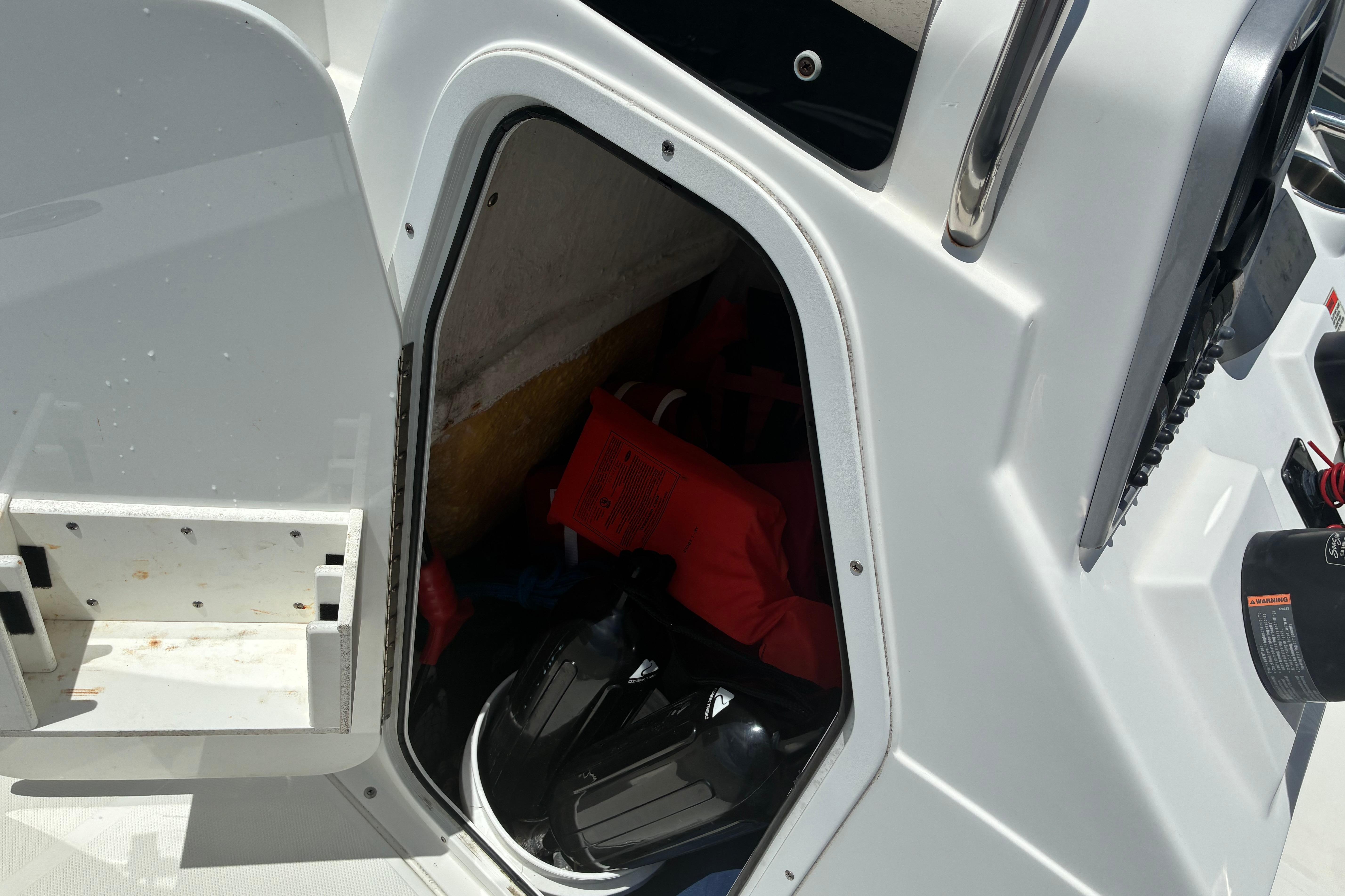 Storage compartment of 2014 Sea Hunt BX 20 BR boat with life jackets and gear.