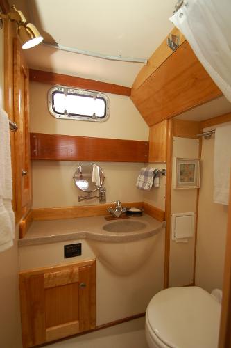 The image shows a bathroom with wood paneling, a sink, and a small window.