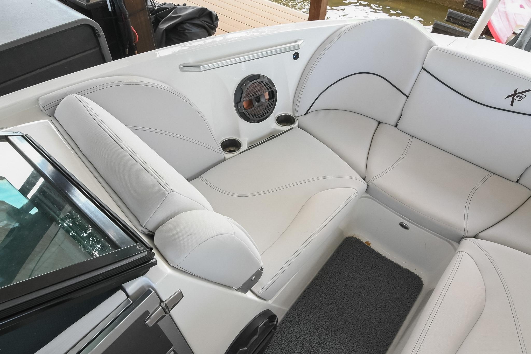 Interior seating of 2018 MasterCraft X23 boat with white upholstery and speaker system.