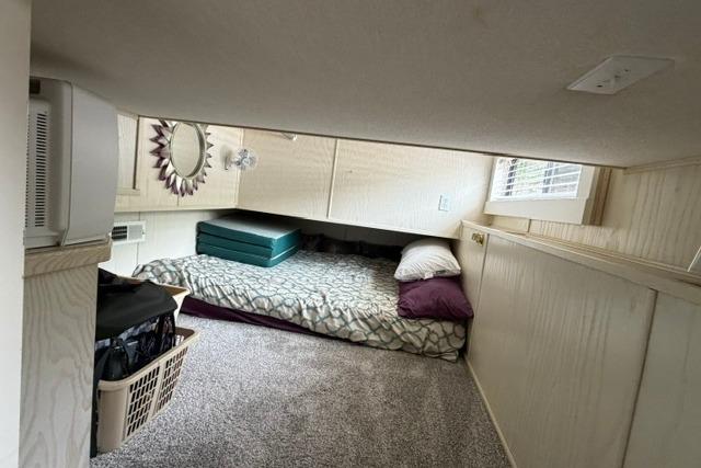 Cozy bedroom in 1997 Stardust Houseboat 18x83 with carpet and compact storage.