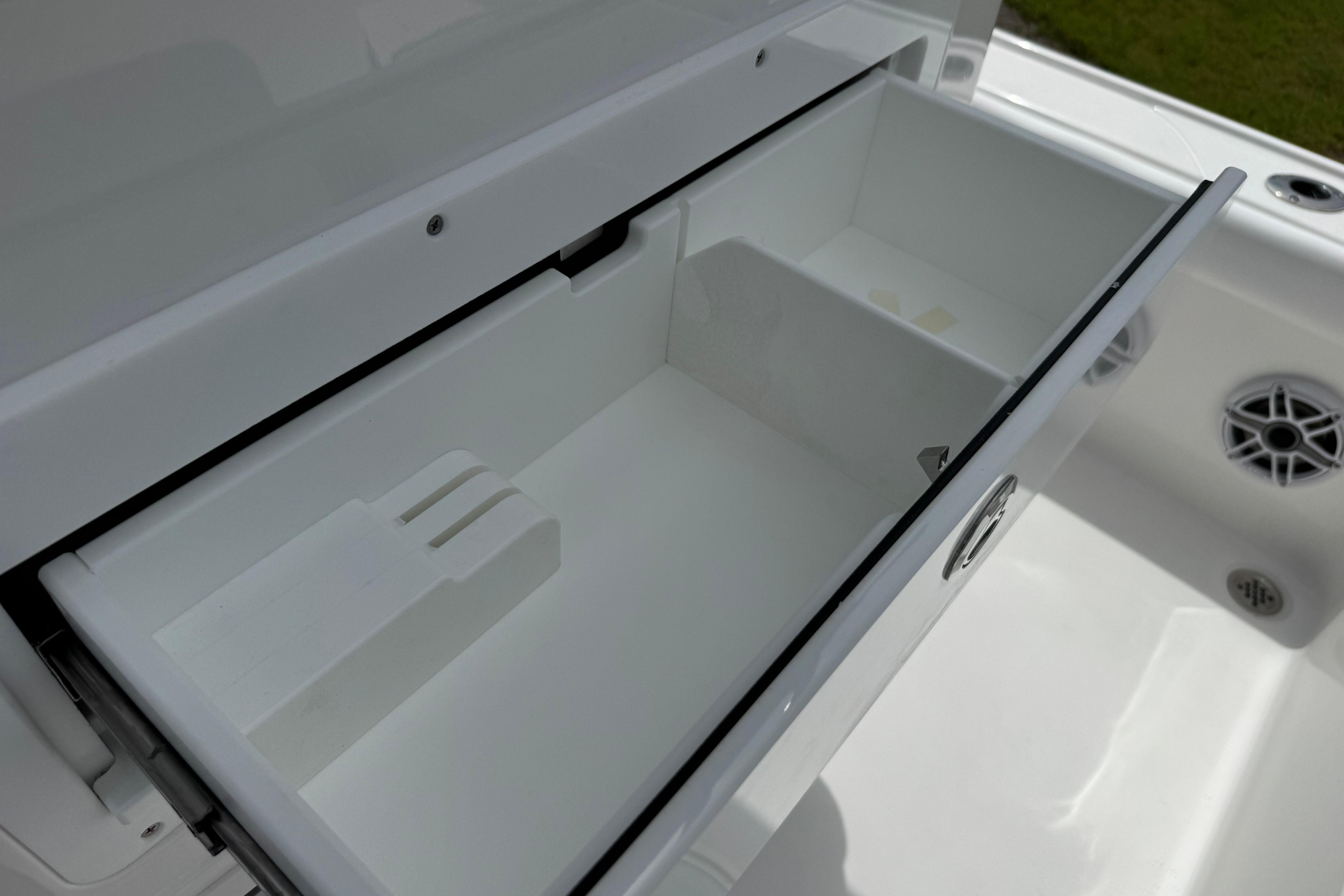 Open storage compartment on 2027 Caymas 26 HB boat, showcasing sleek design and functionality.