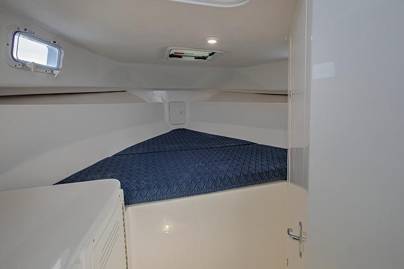 Manufacturer Provided Image: 2026 NorthCoast 255 HT cabin interior with blue bedding and small window.